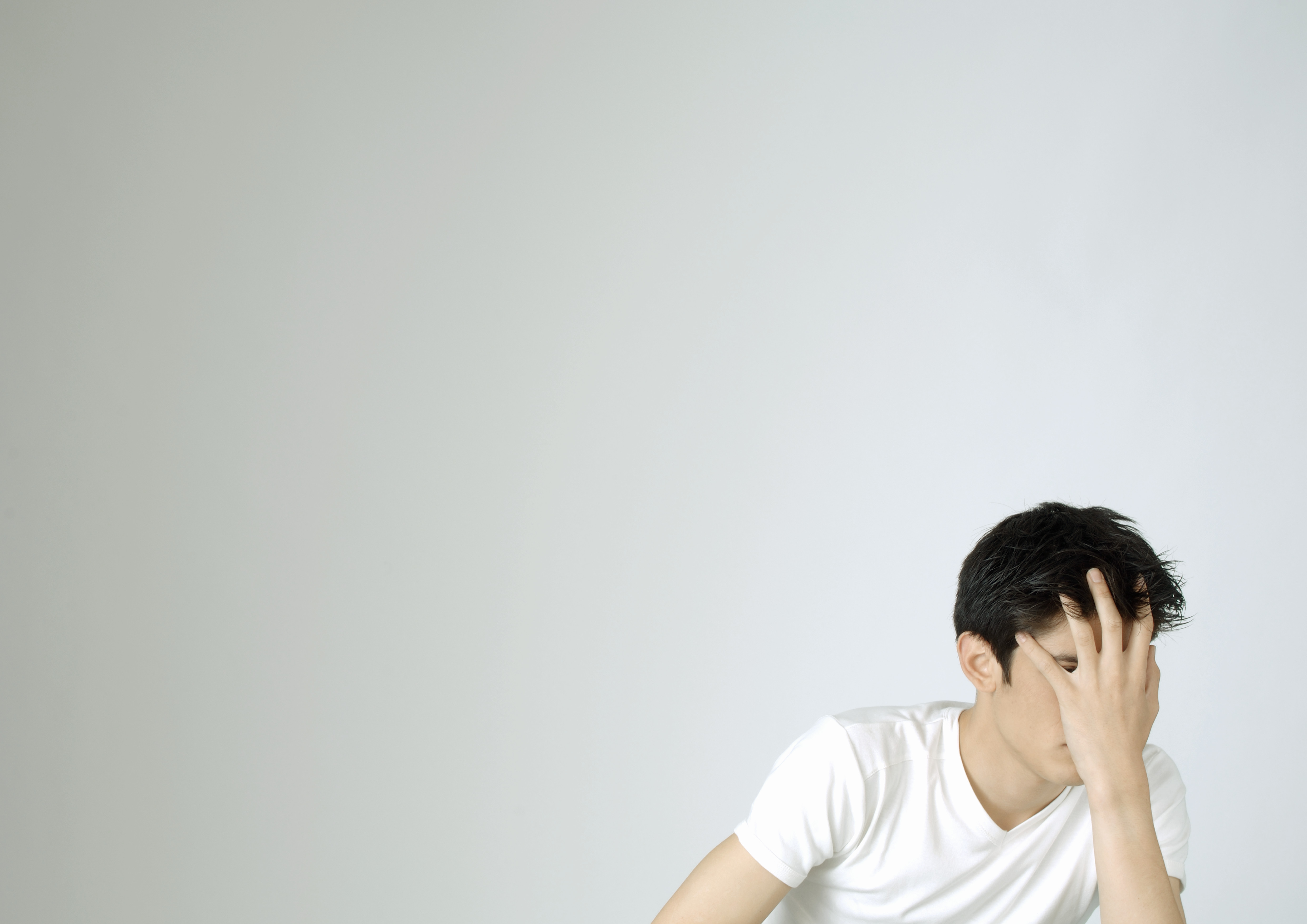 Young man covering face with hand TIME health stock