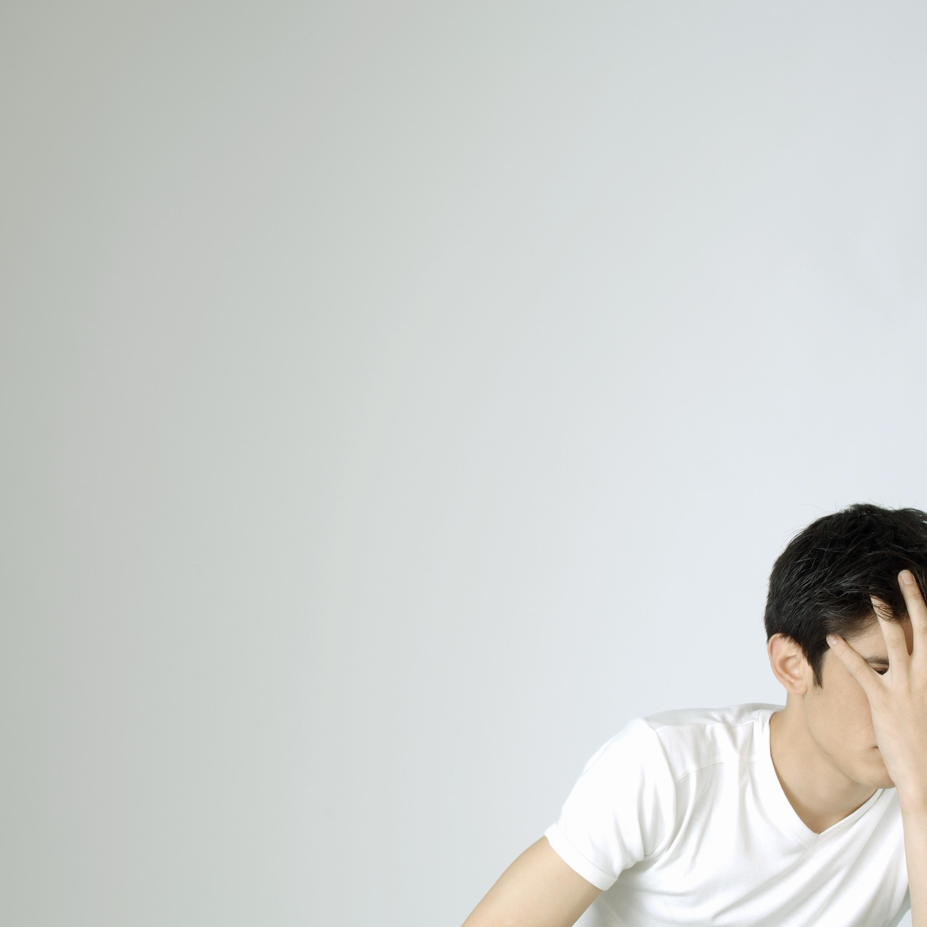 Young man covering face with hand TIME health stock