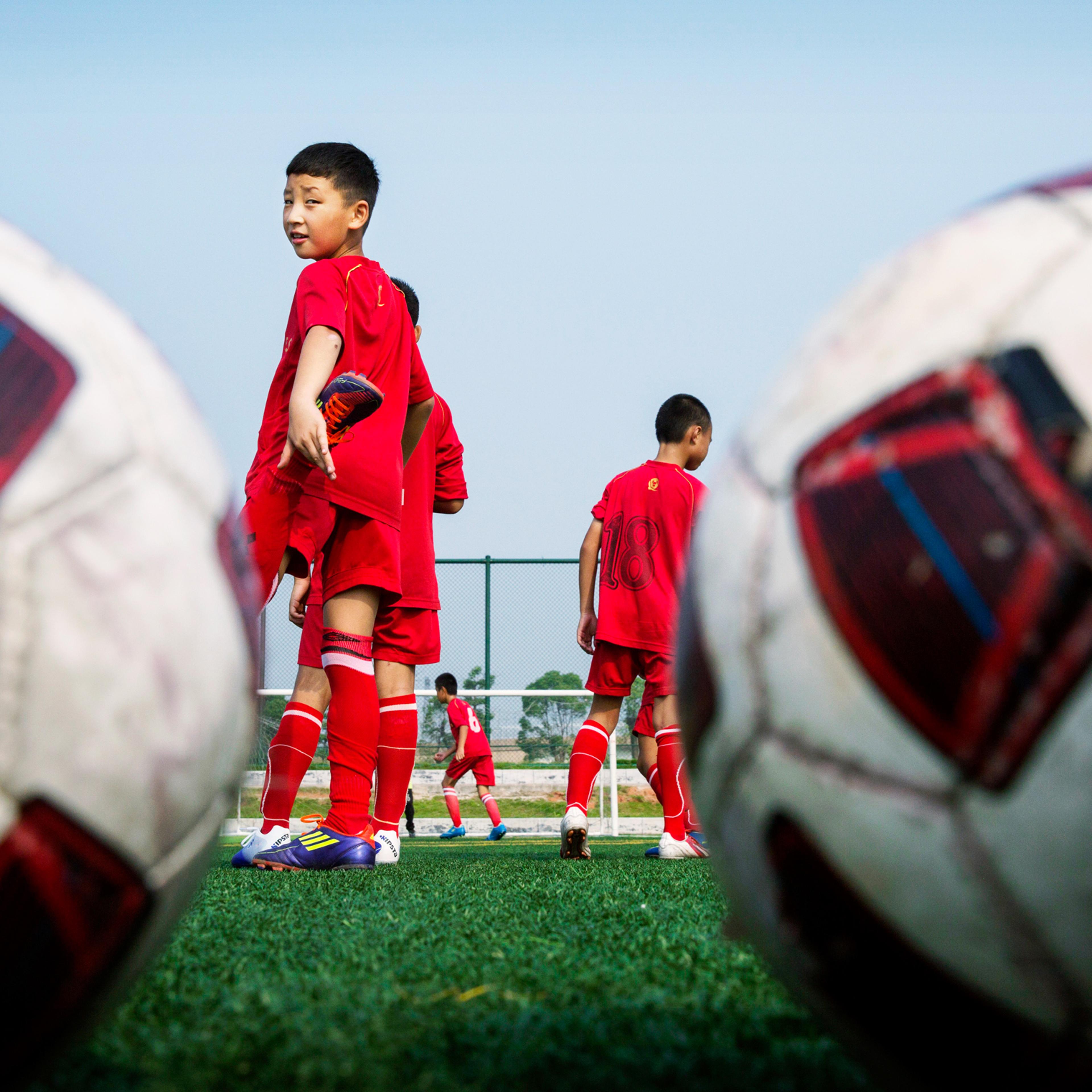 Chinese students wait their turn during training at the Evergrande Football School near Qingyuan