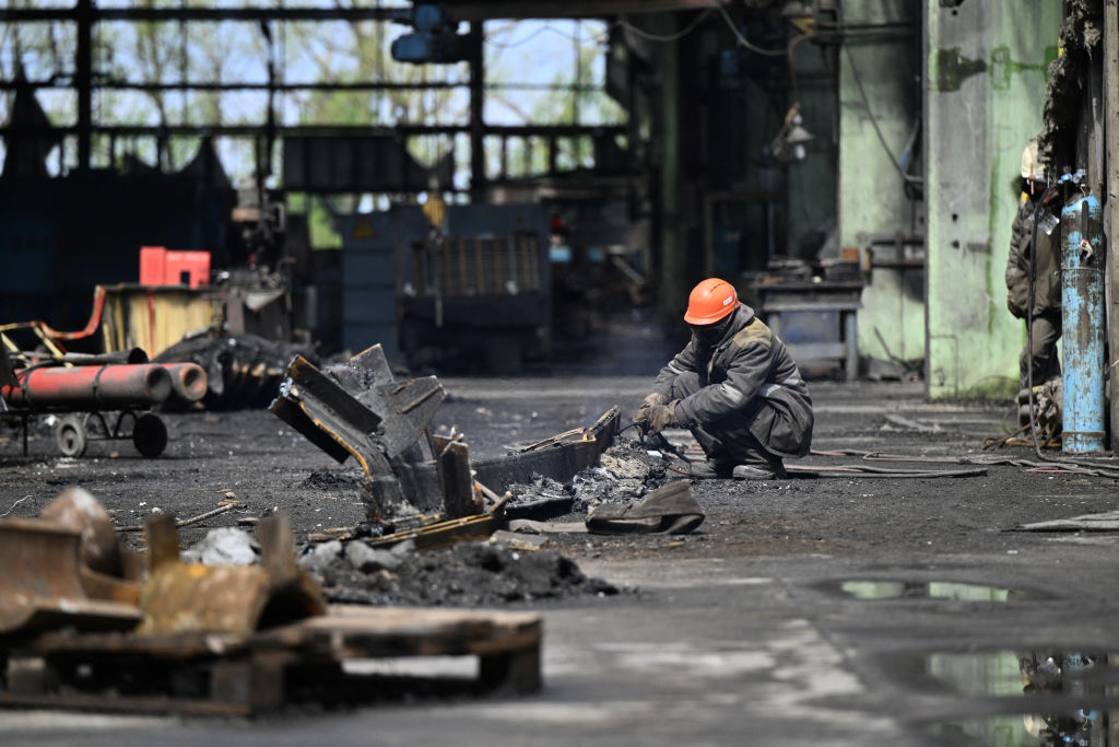 Workers clean debris in a turbine hall full of scorched equipments at a power plant of energy provider DTEK, destroyed after an attack, in an undisclosed location in Ukraine on April 19, 2024.