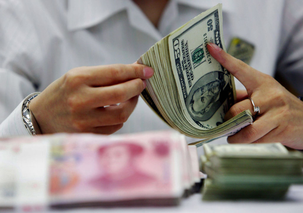 CHINA OUT A bank teller counts the stack