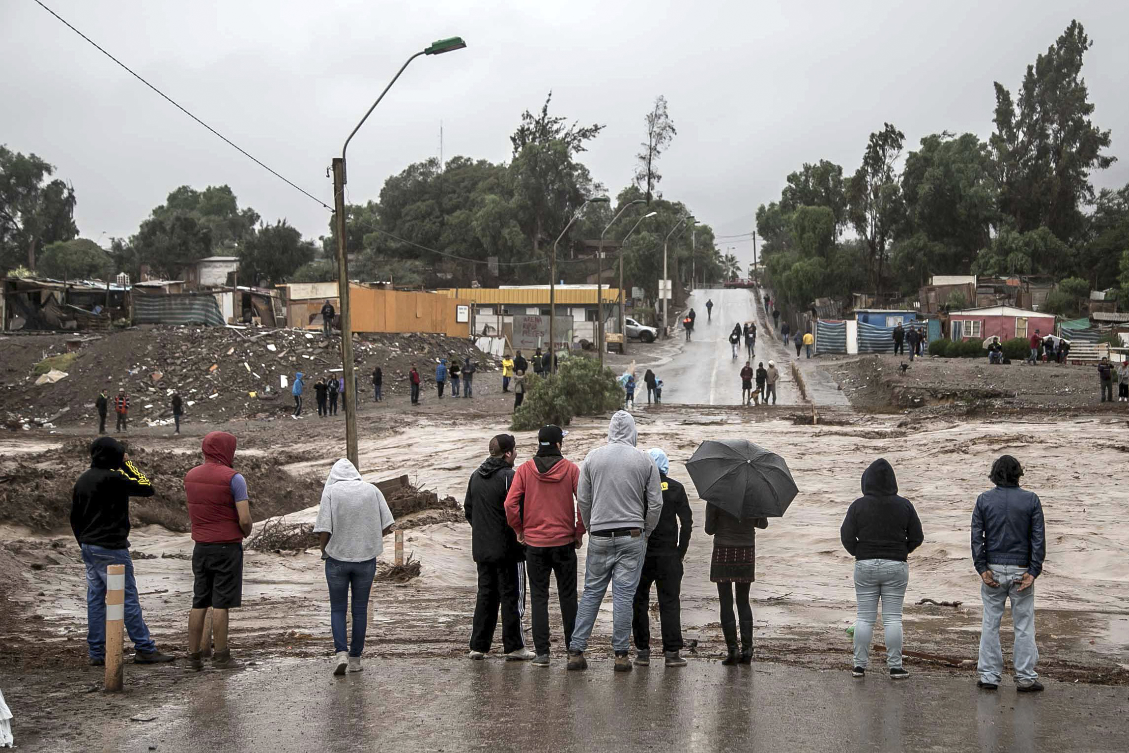 Residents watch the rising flood waters of the Copiapo River, in Copiapo, Chile, March 25, 2015