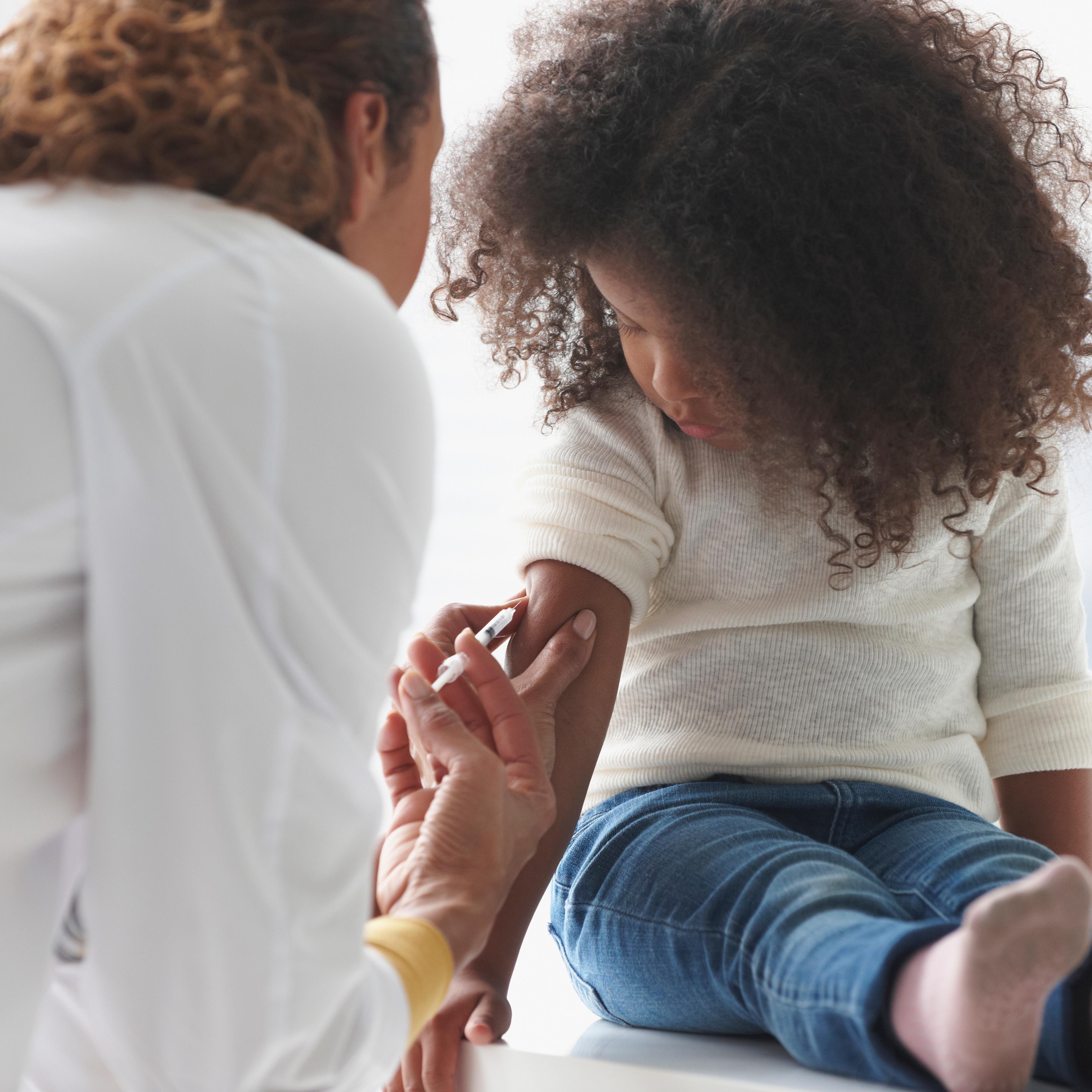 Doctor vaccinating girl in office