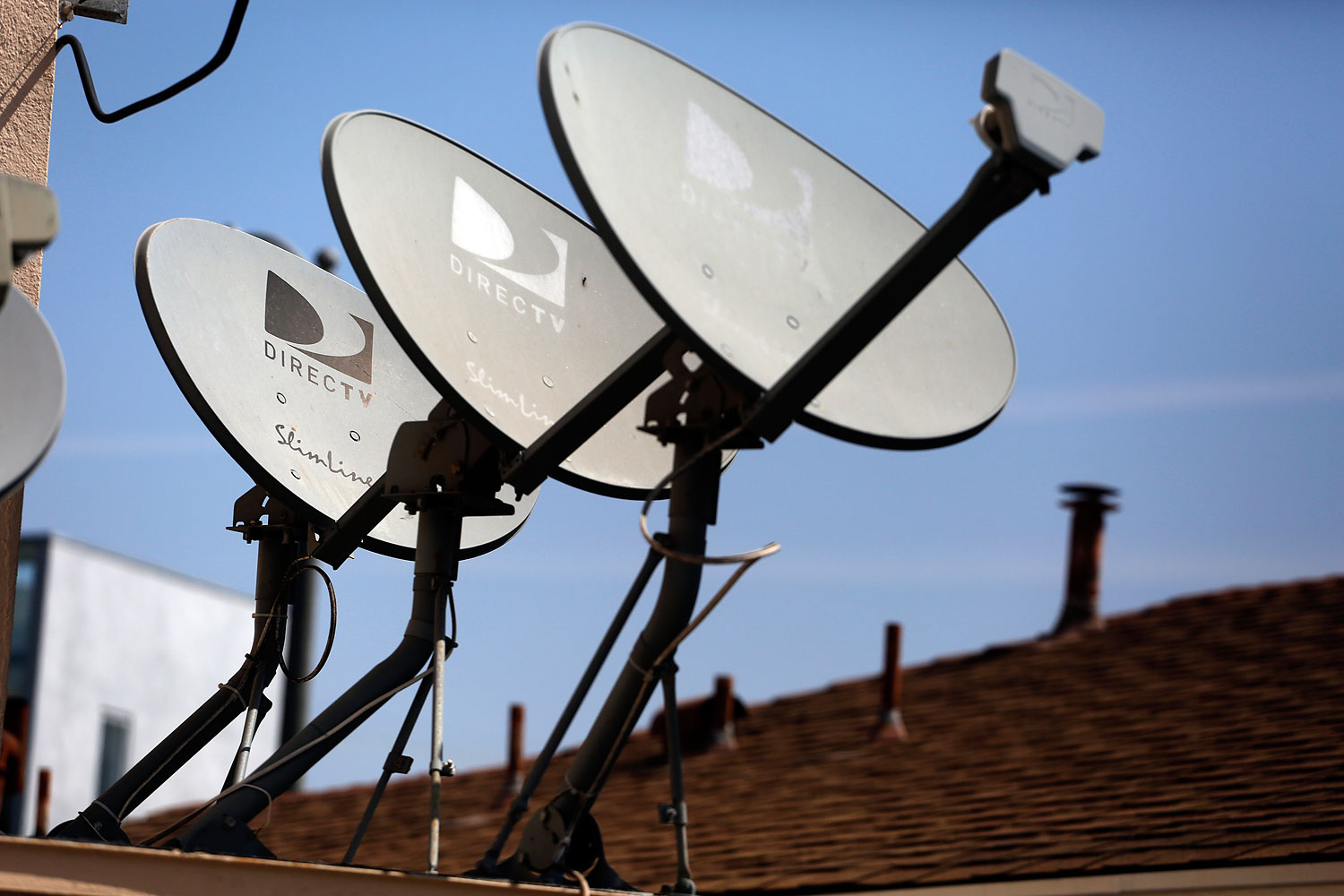 DirecTV satellite dishes are seen on an apartment roof in Los Angeles