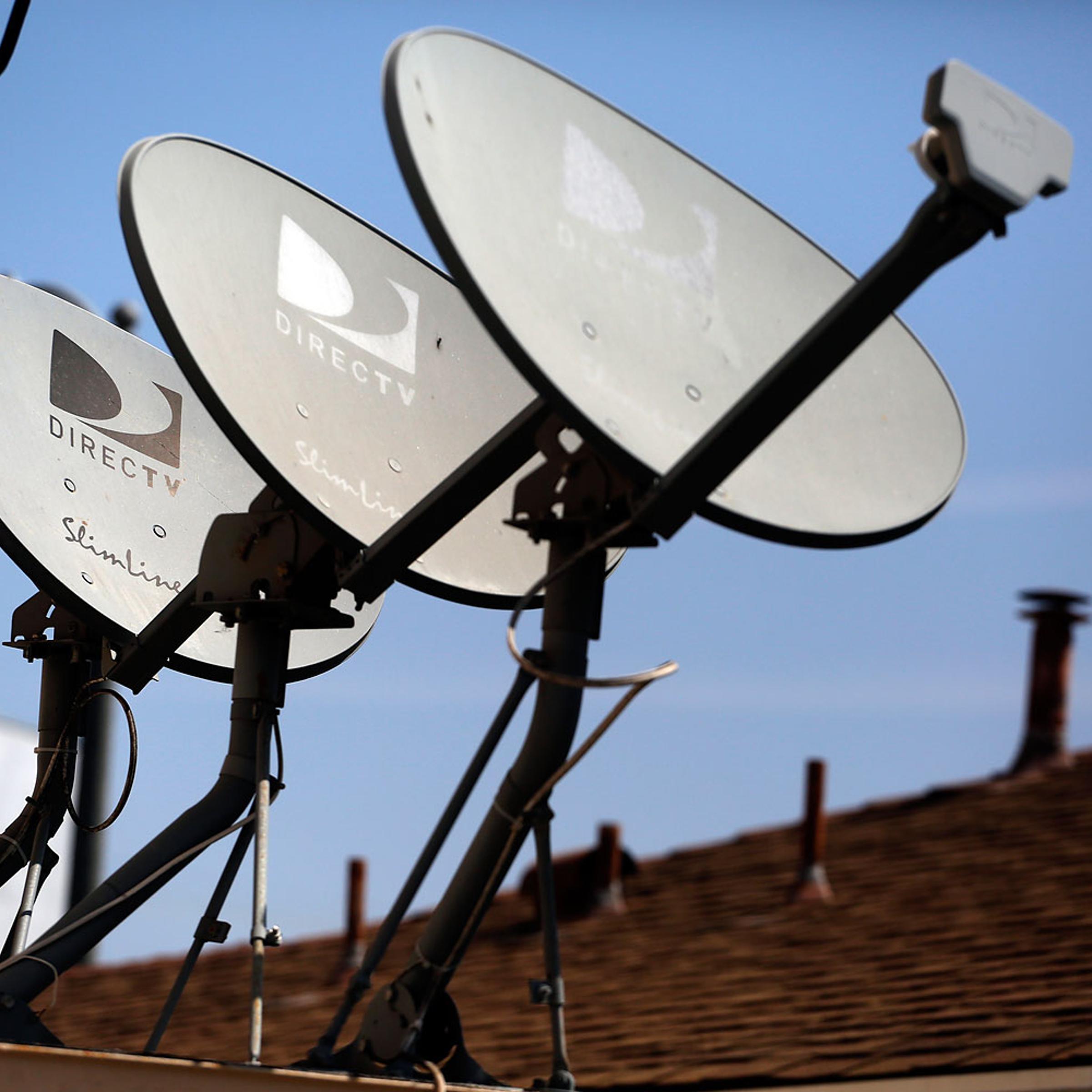 DirecTV satellite dishes are seen on an apartment roof in Los Angeles