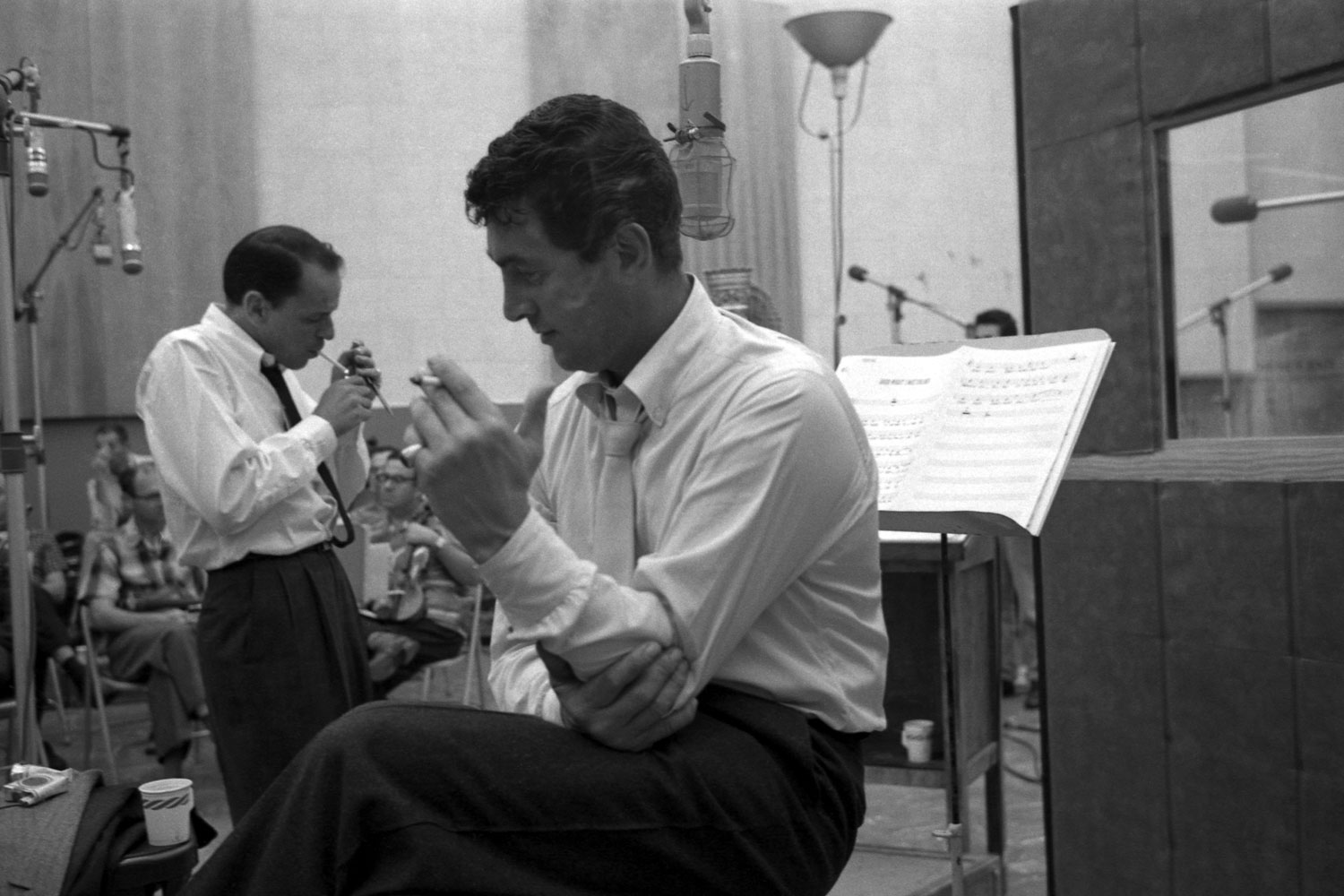 Frank Sinatra and Dean Martin take a cigarette break during the recording of Sleep Warm in 1958.