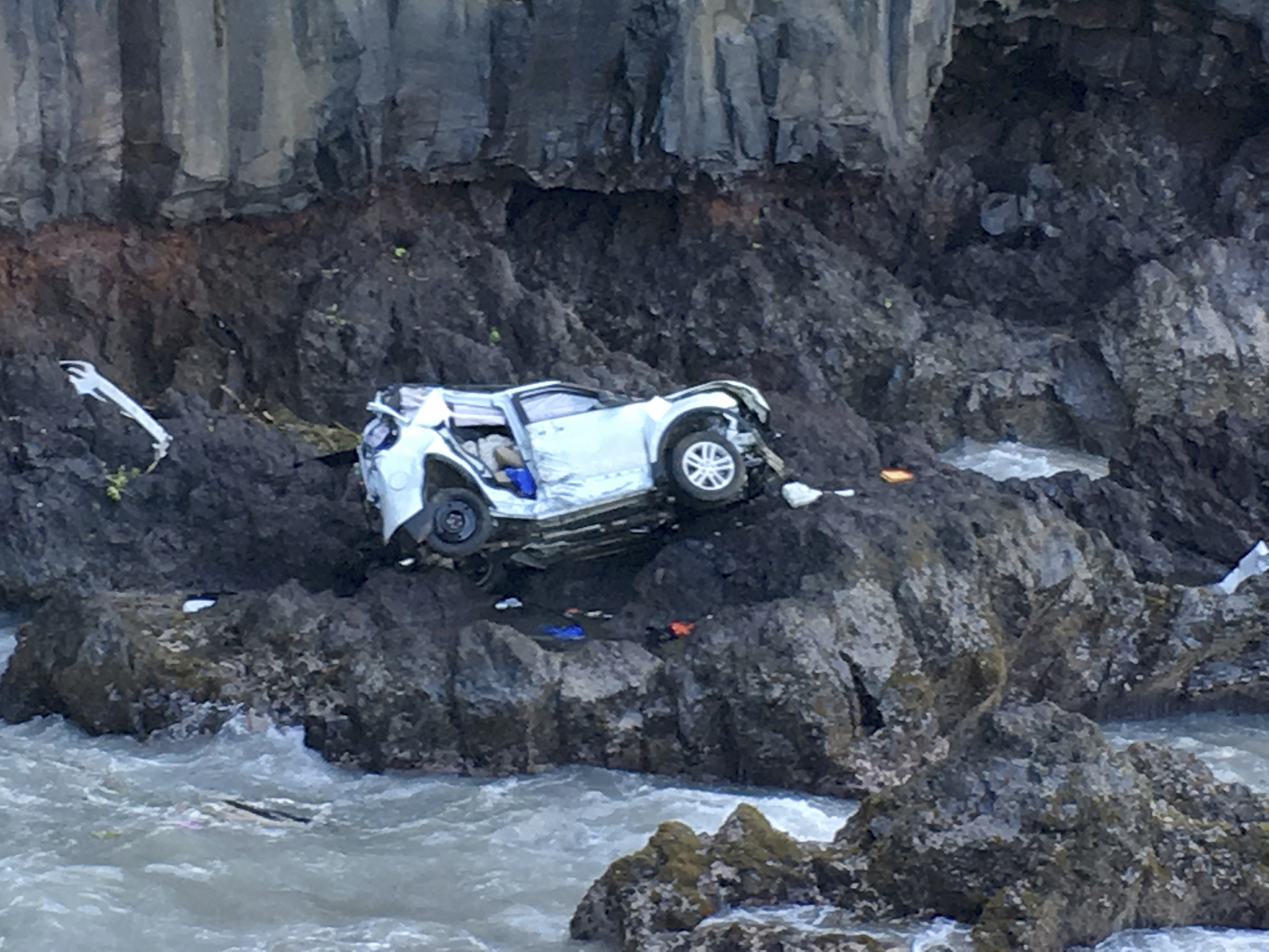 In this May 29, 2016, photo provided by Tom Johnson, a vehicle sits at the bottom of a cliff off Maui’s Hana Highway in Hana, Hawaii. Police say the Ford Explorer fell about 200 feet. Prosecutors say Alexandria Duval, who is also known as Alison Dadow, i