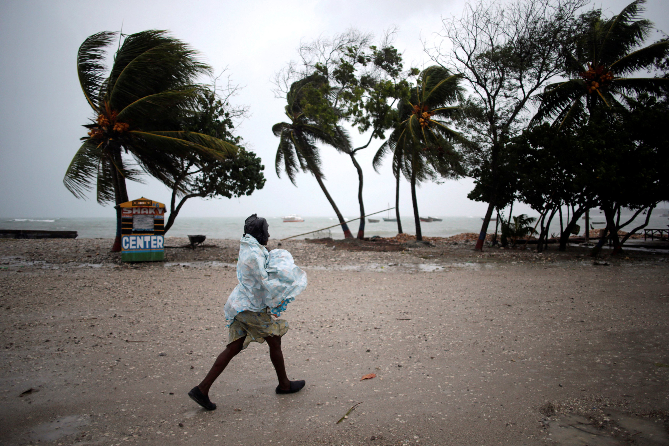 A woman protects herself from rain as Hurricane Matthew approaches in Les Cayes, Haiti, October 3, 2016. REUTERS/Andres Martinez Casares TPX IMAGES OF THE DAY