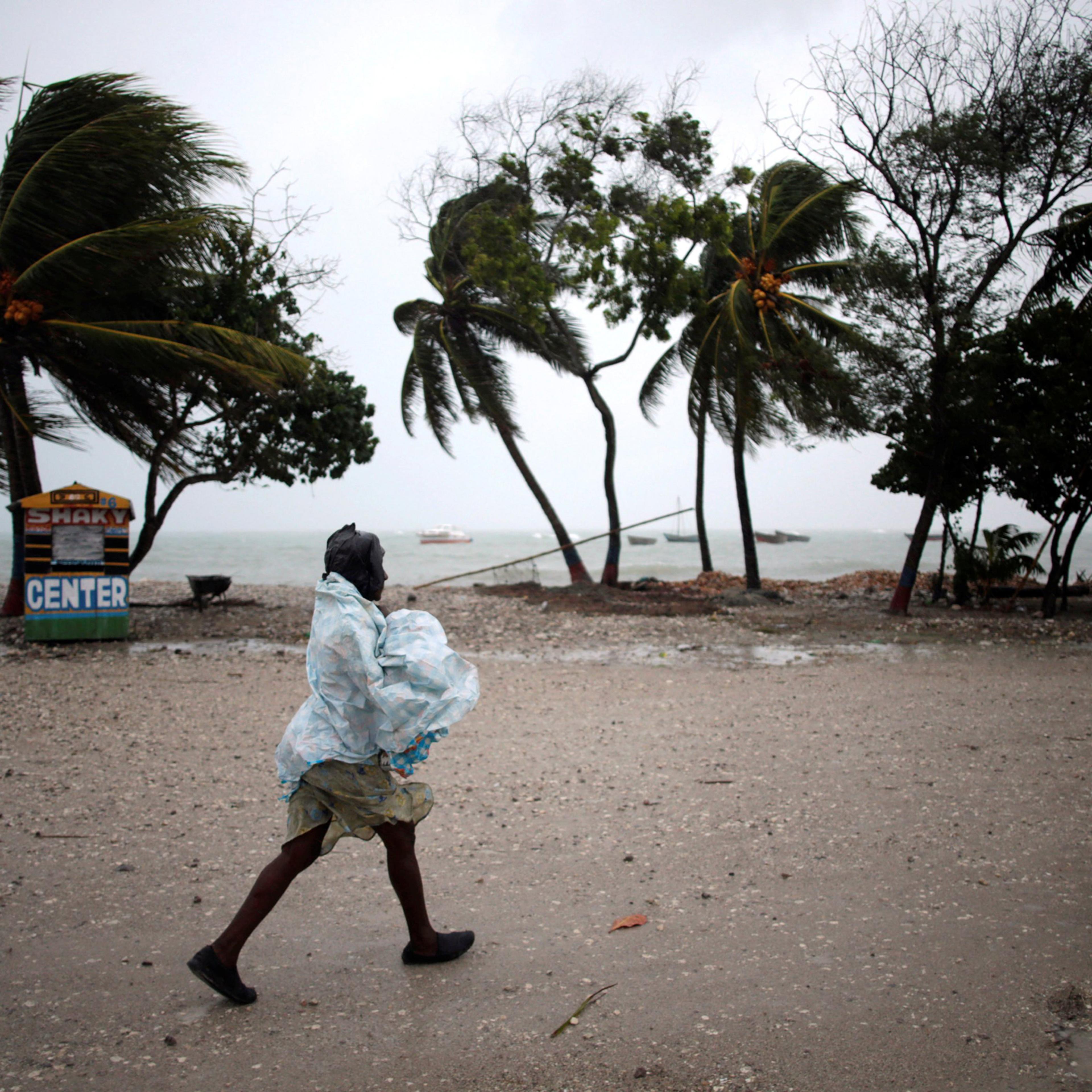 A woman protects herself from rain as Hurricane Matthew approaches in Les Cayes, Haiti, October 3, 2016. REUTERS/Andres Martinez Casares TPX IMAGES OF THE DAY