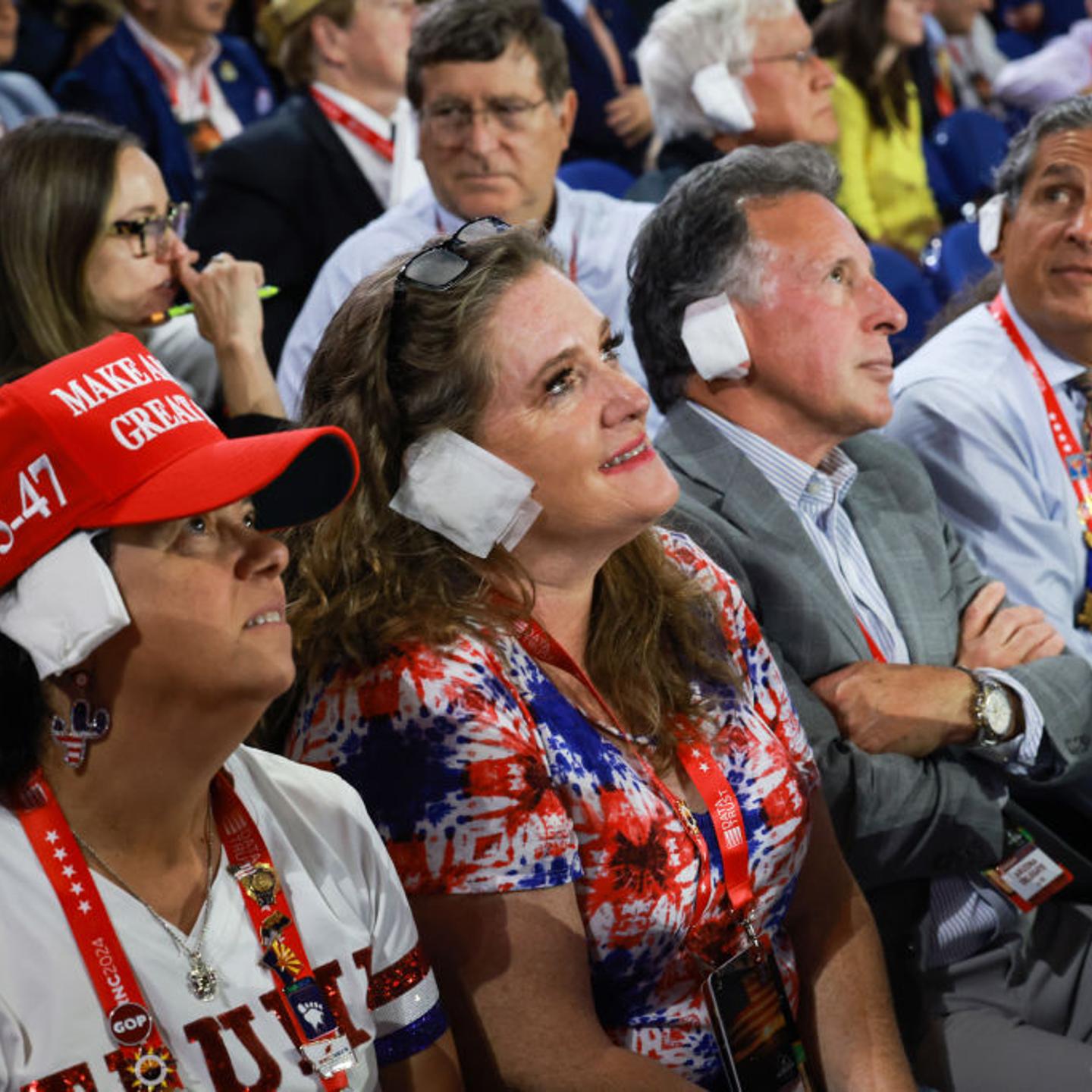 People wear fake bandages on their ears as they watch on the third day of the Republican National Convention at the Fiserv Forum in Milwaukee, Wisconsin, on July 17, 2024.