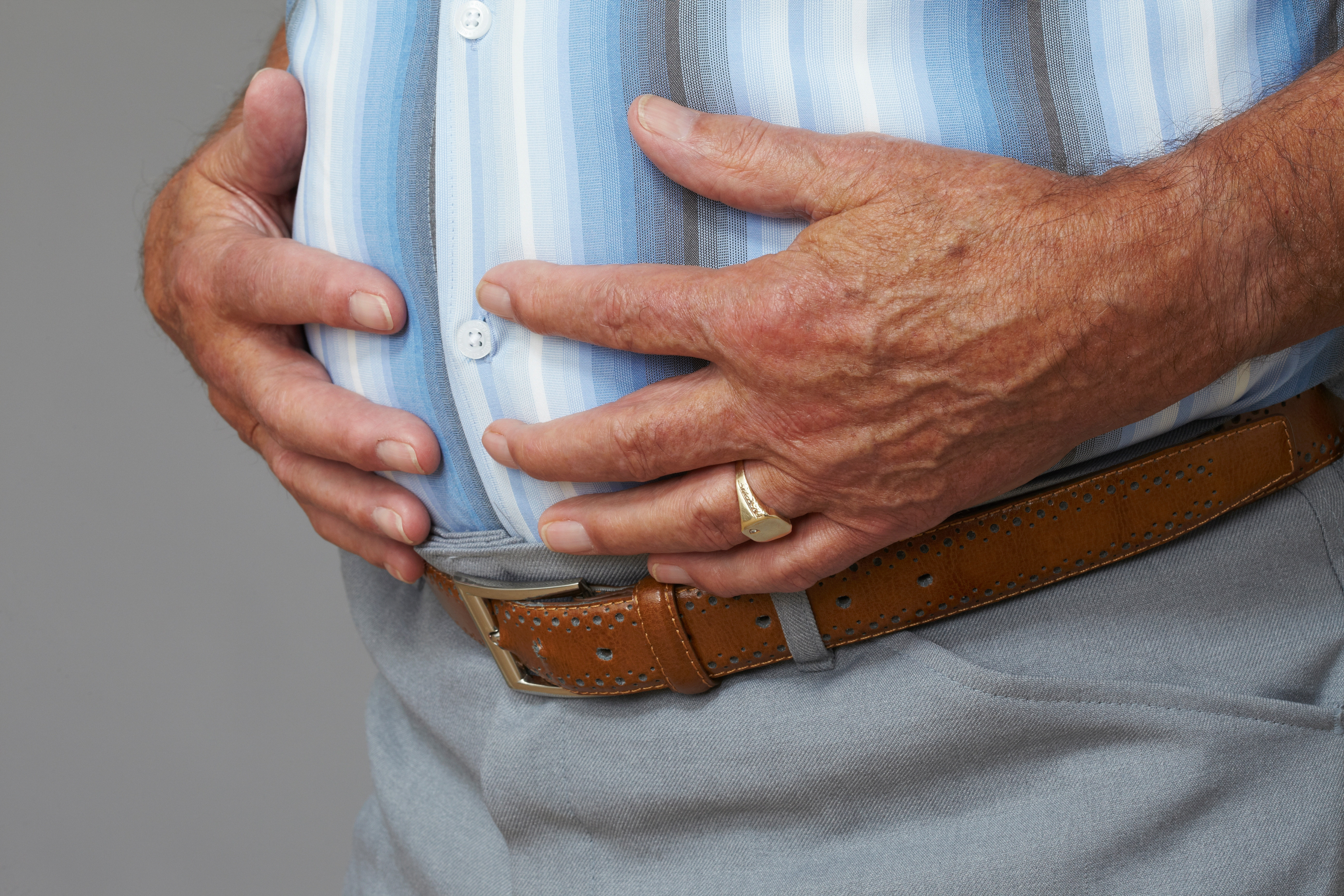 Overweight senior man touching stomach