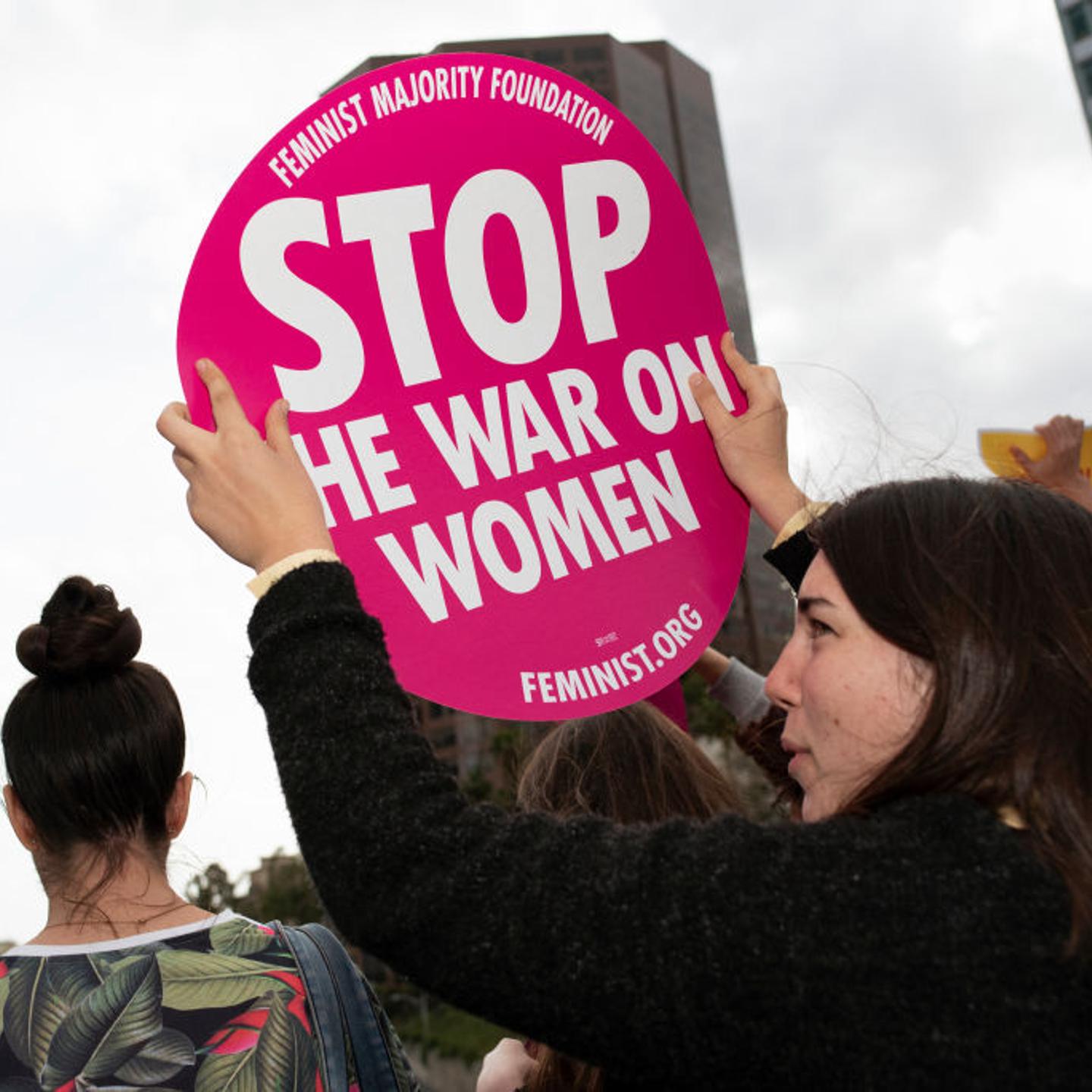 An activist seen holding a placard that says Stop The War On