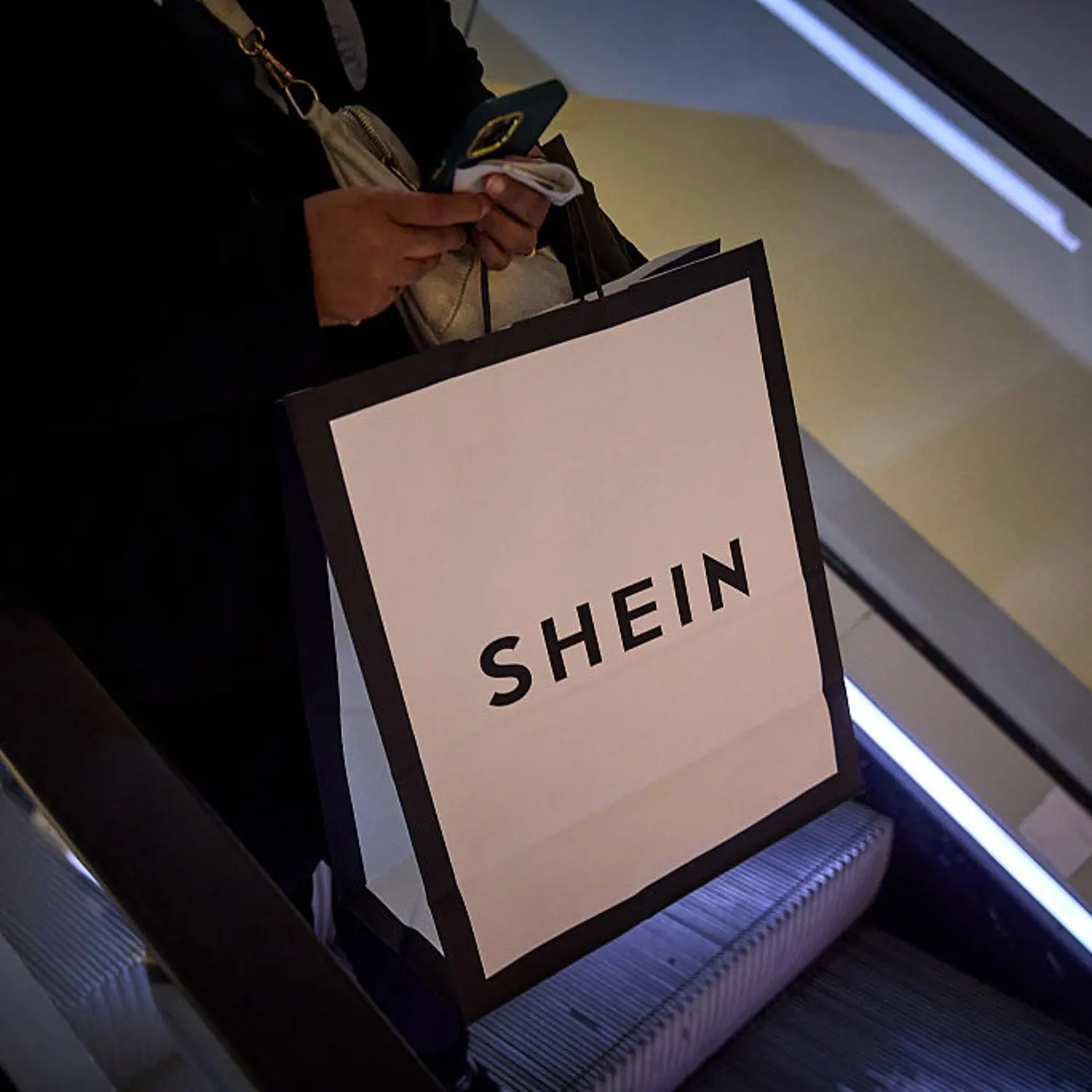 A shopper carries a bag of the Asian fast fashion brand Shein after visiting their first physical store on its opening day, in the BHV Marais Department Store in Paris, France, on Nov. 5, 2025.