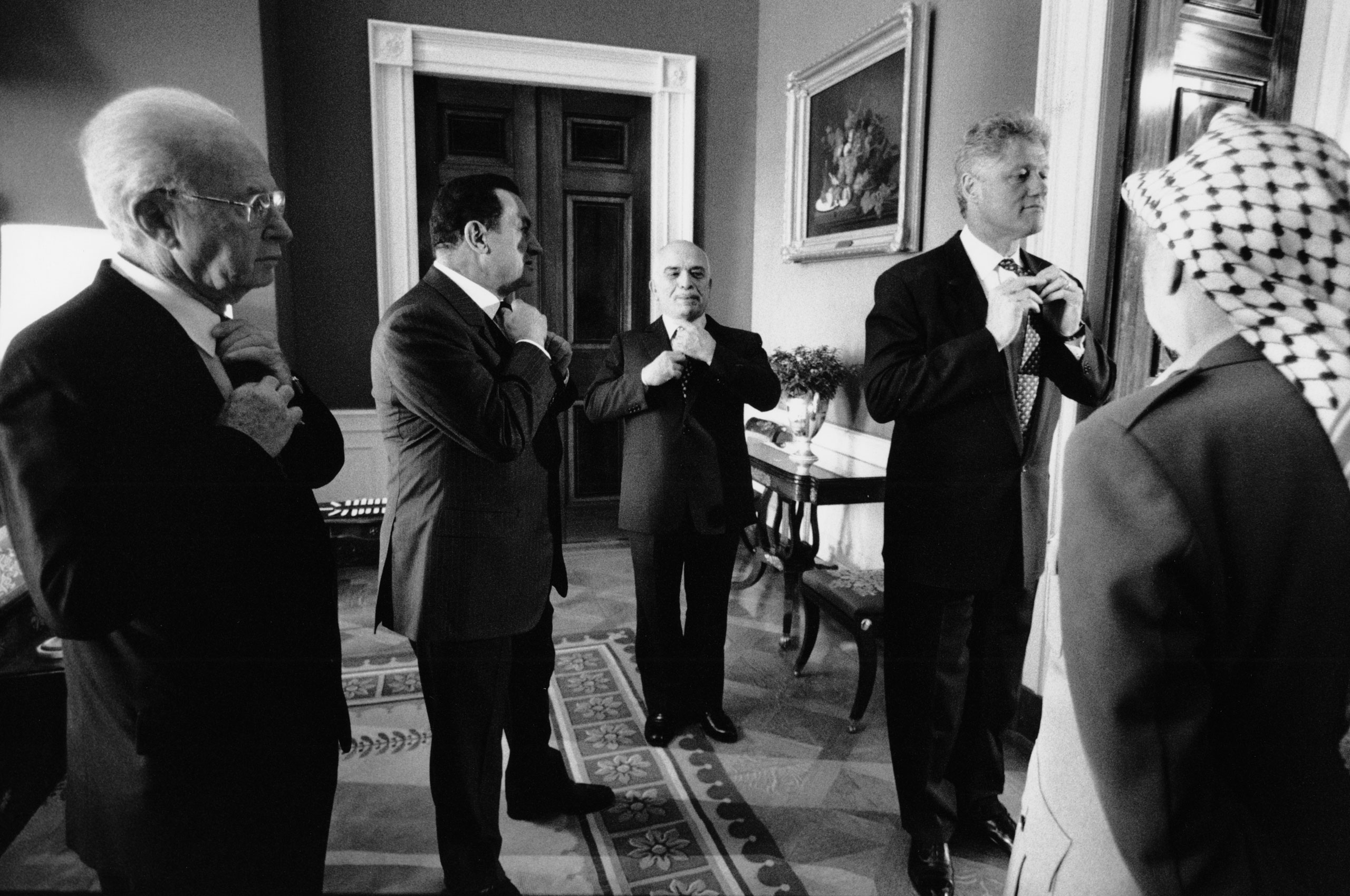Palestine Liberation Organization leader Yasser Arafat, Israeli Prime Minister Yitzhak Rabin, Egyptian President Hosni Mubarak and King of Jordan Hussein bin Talal take a cue from President Bill Clinton, all adjusting their ties before the ceremony to sign an accord expanding Palestinian self-rule in the West Bank, Sept. 28, 1995.