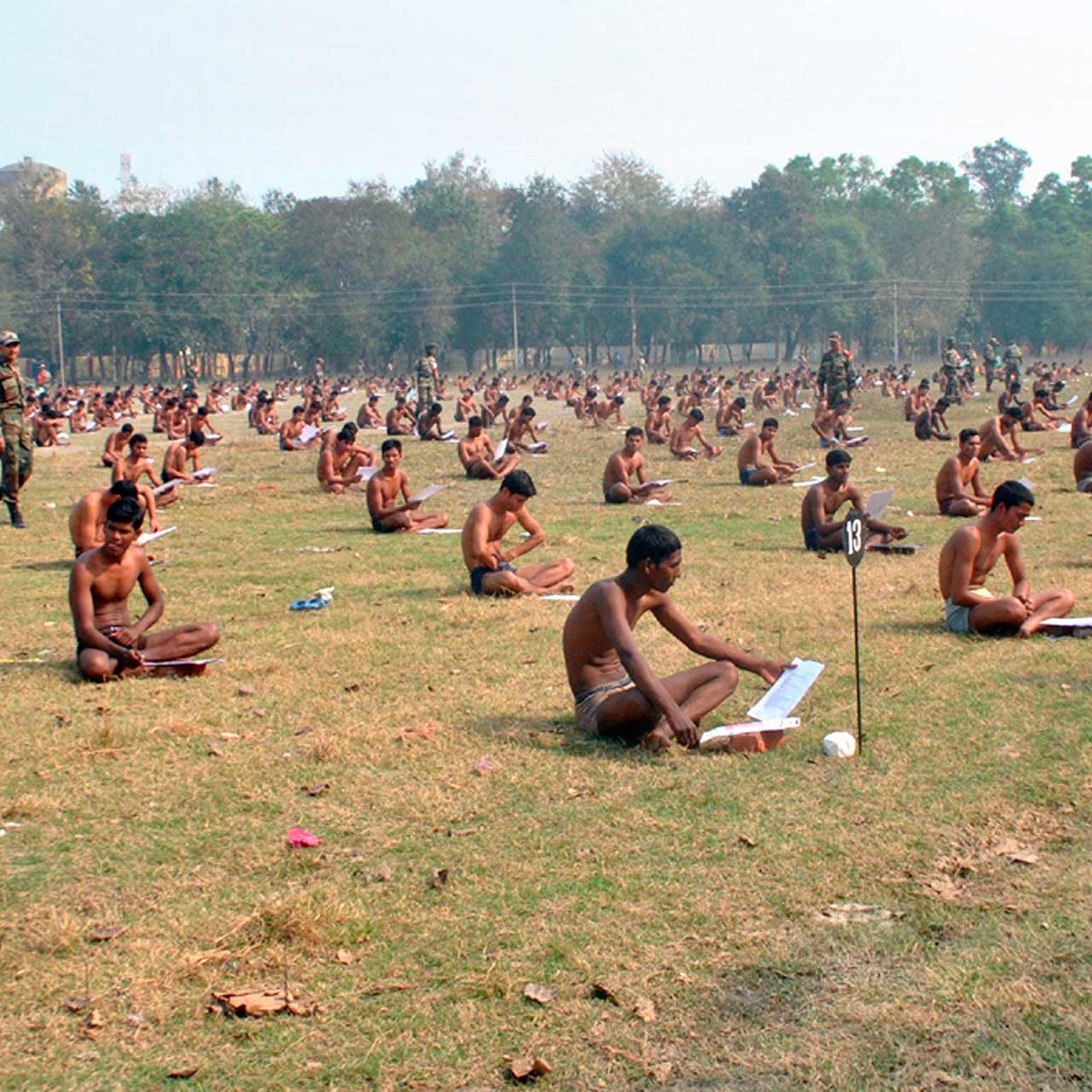 Indian army candidates sit in their underwear as they take a written exam in a field after being asked to remove their clothing to deter cheating in Muzaffarpur, India, Feb. 28, 2016.