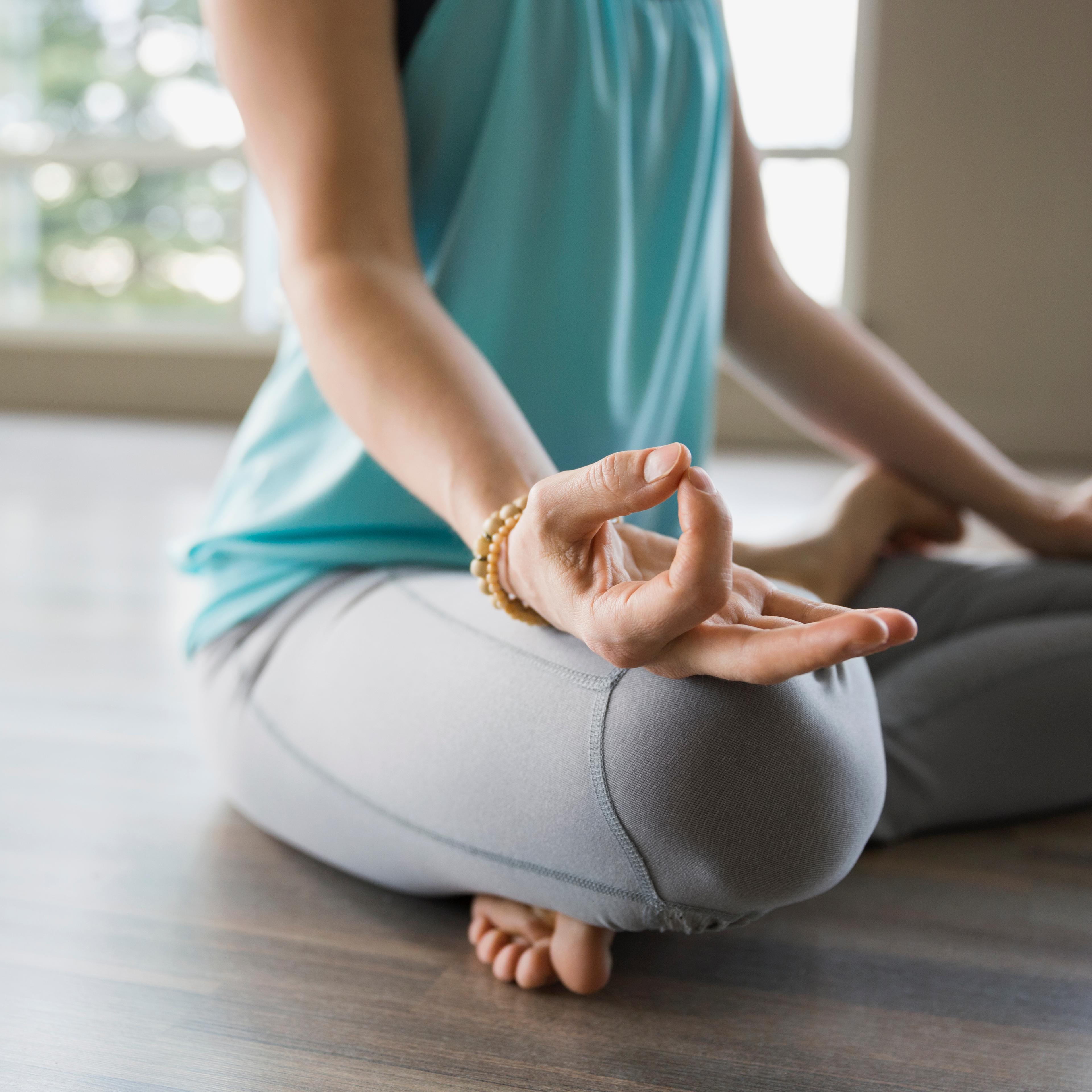 Woman in lotus position practicing mudra meditation