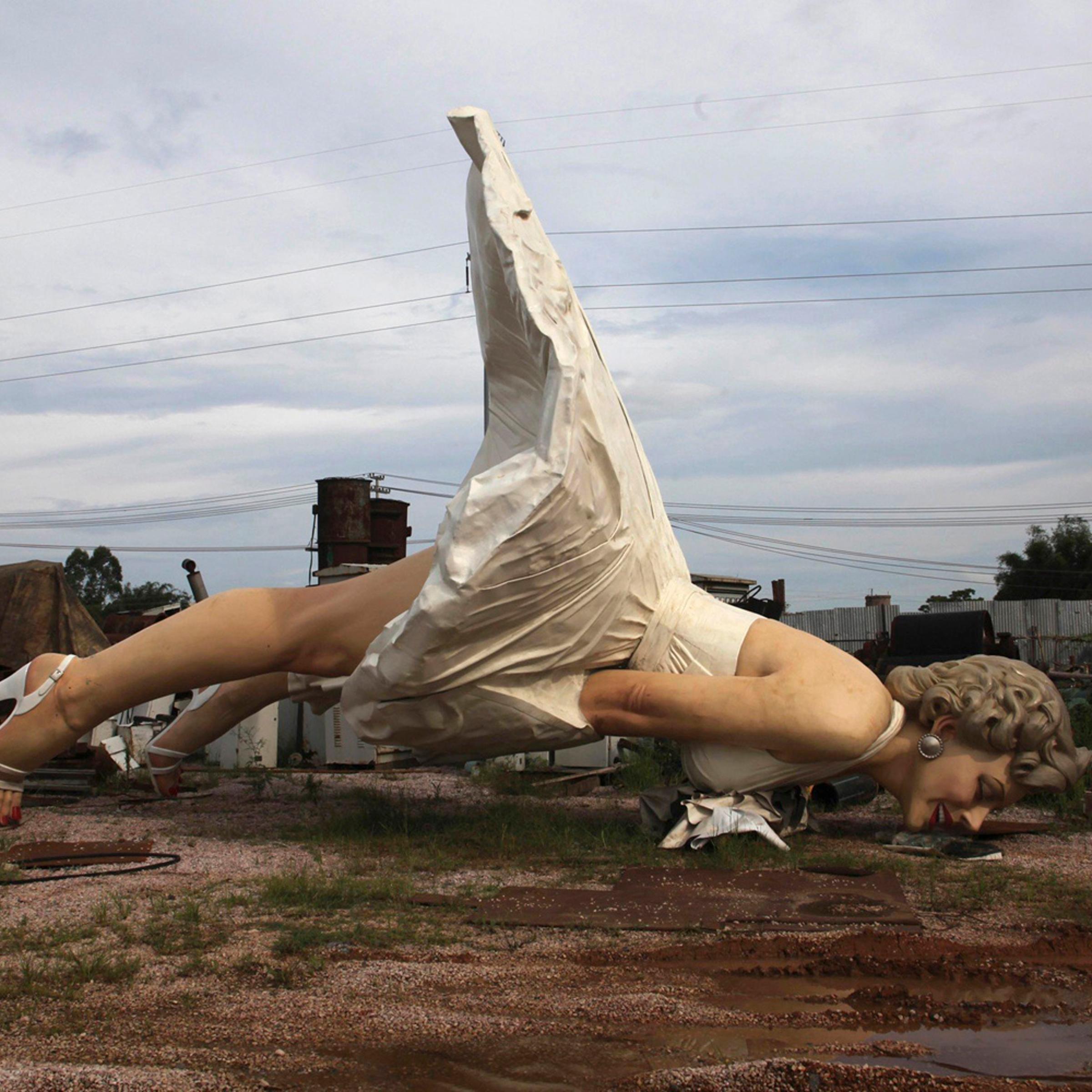 Giant statue of U.S. actress Marilyn Monroe is seen at the dump site of a garbage collecting company in Guigang