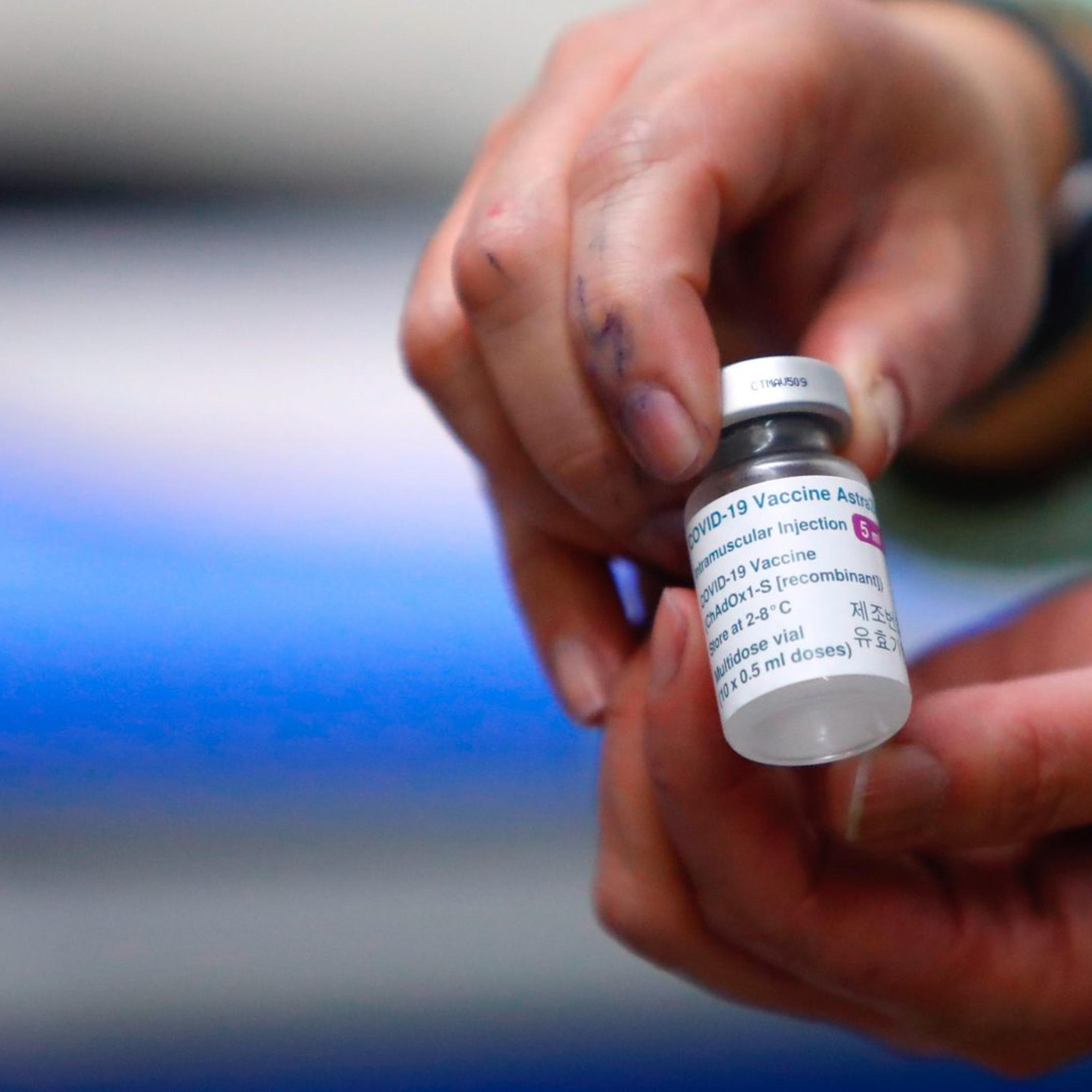 A nurse holds a vial with a dose of AstraZeneca vaccine