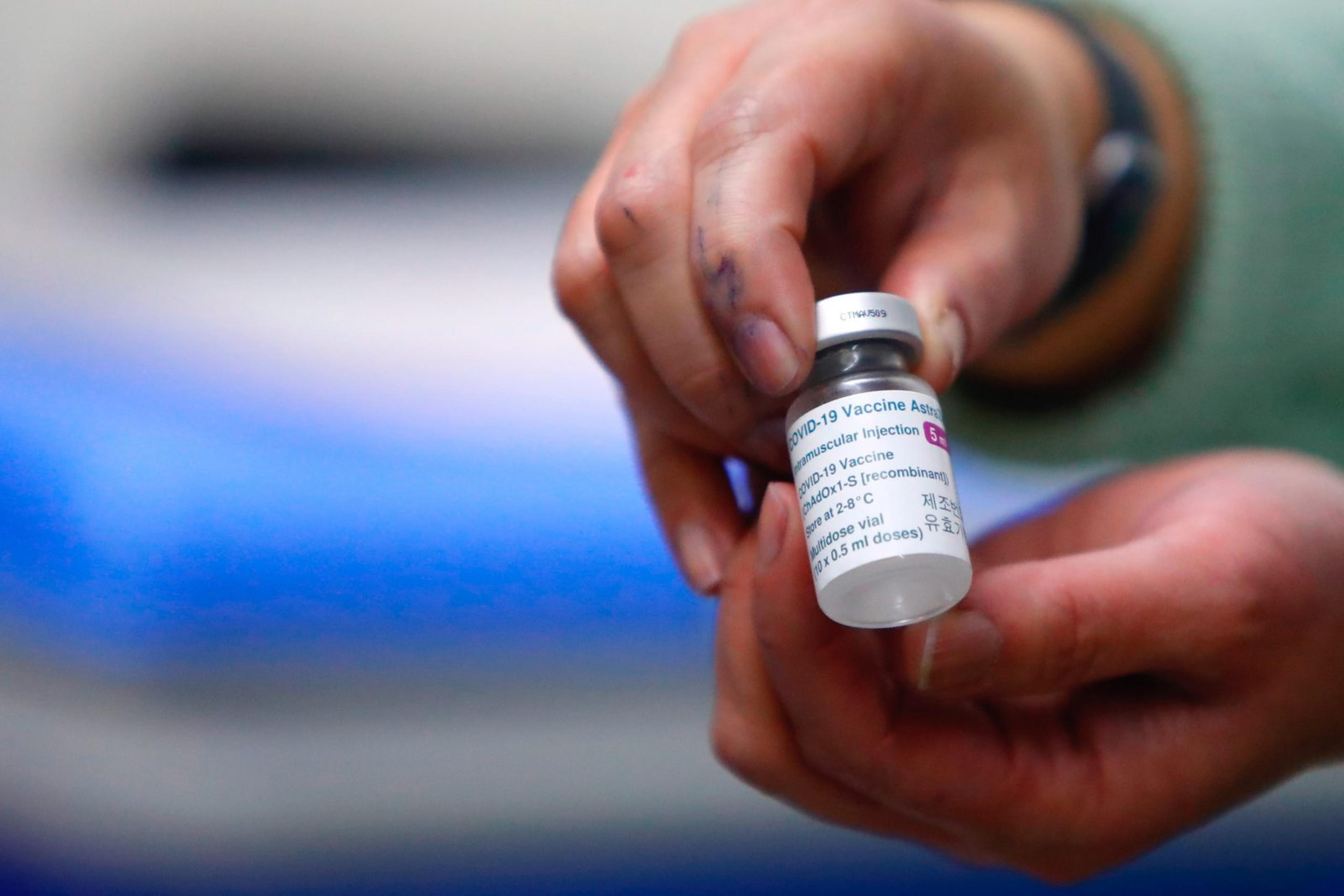 A nurse holds a vial with a dose of AstraZeneca vaccine