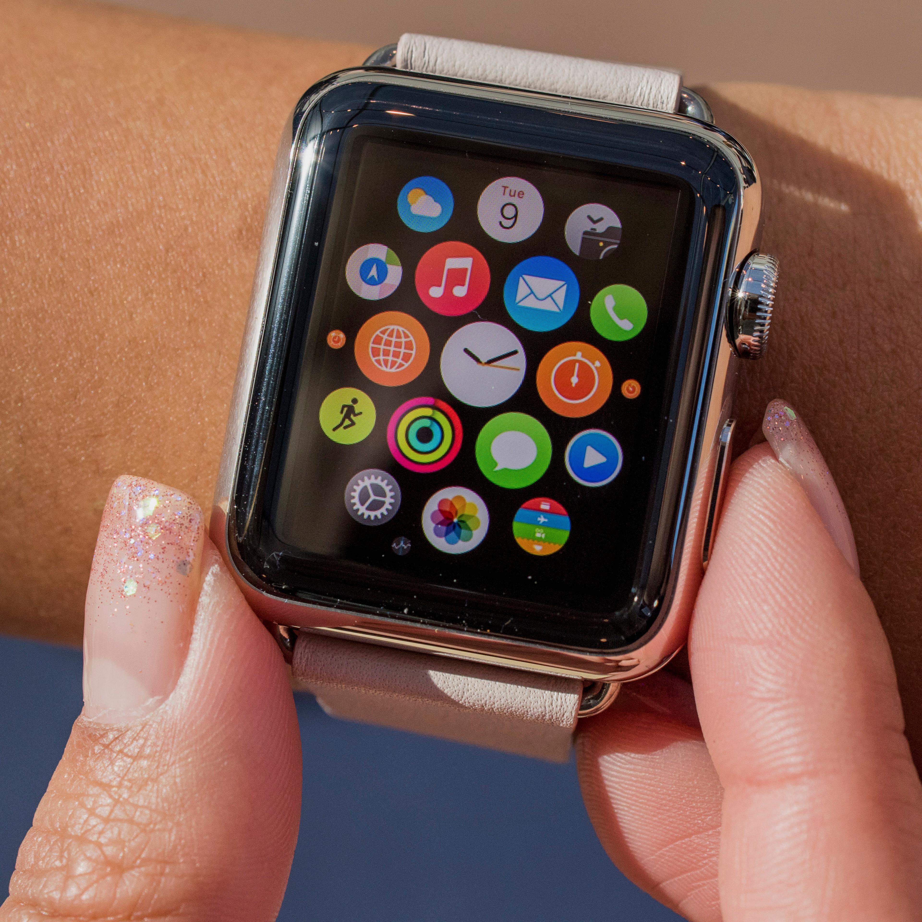 Customers look at Apple Watches on display at an Apple Inc. store in Palo Alto, California, U.S., on Friday, April 10, 2015. From London to Beijing, Apple stores saw few customers lined up before opening Friday as pre-orders started. The first new gadget