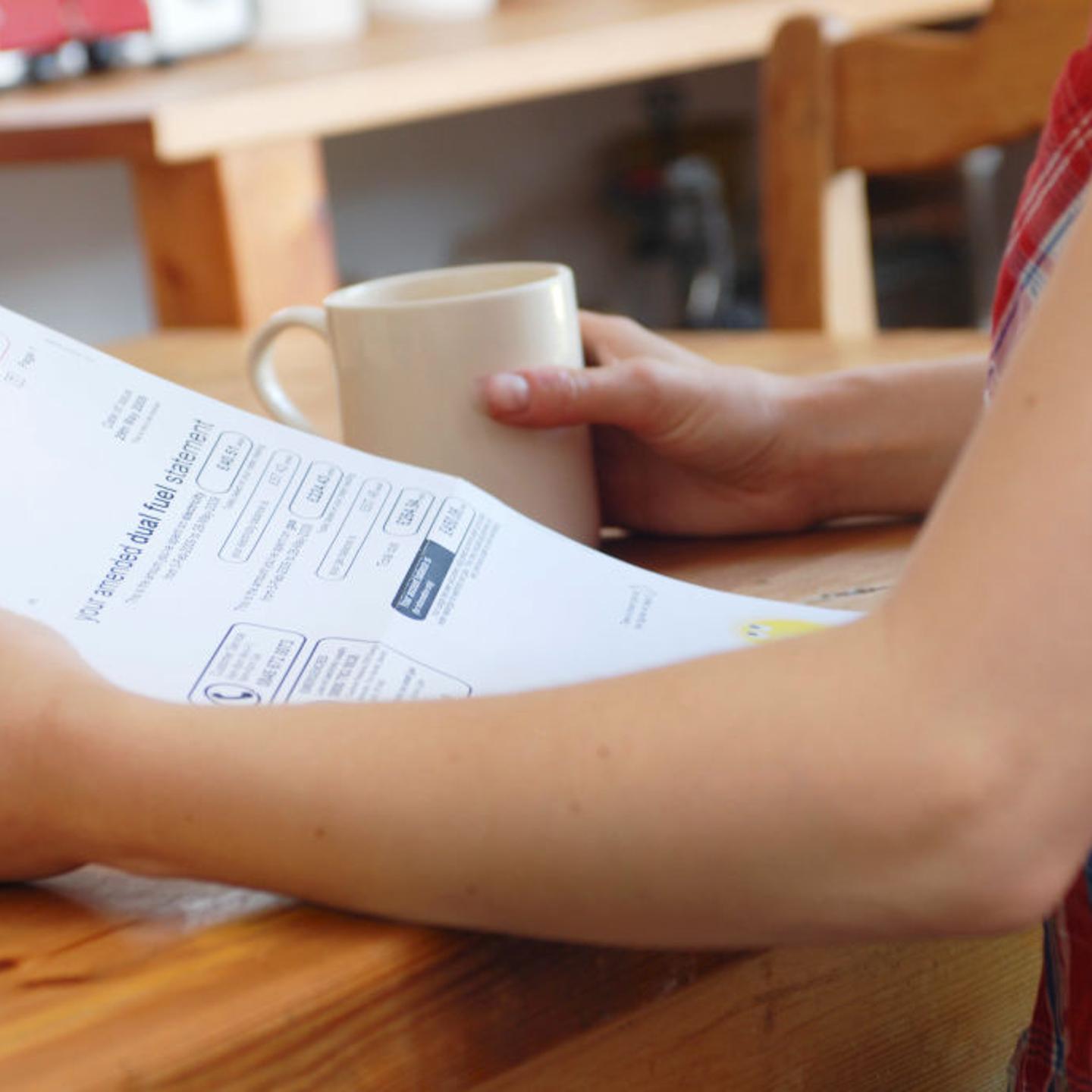 Young woman looking at utility bill.