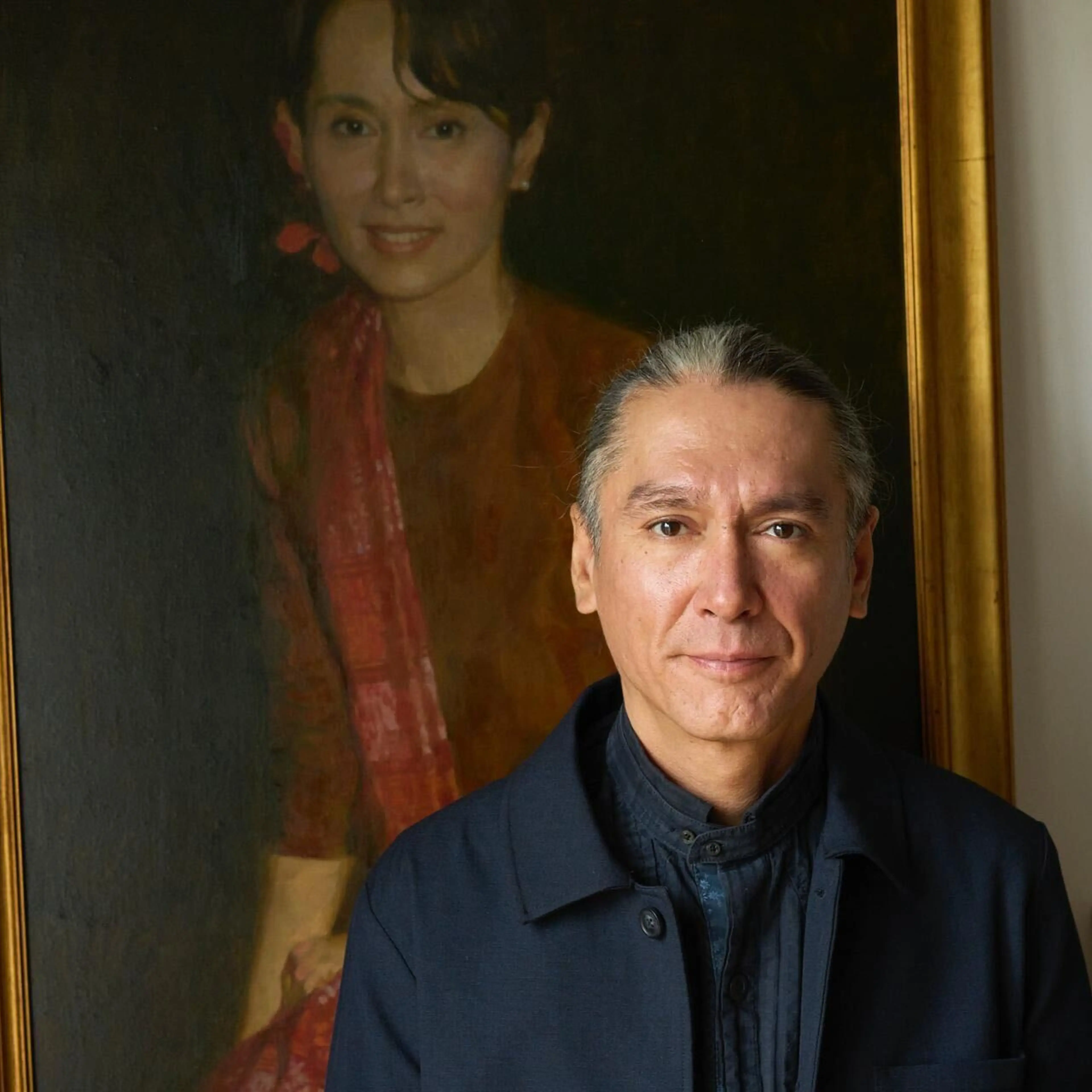 Kim Aris stands before a portrait of his mother, Nobel laureate Aung San Suu Kyi.
