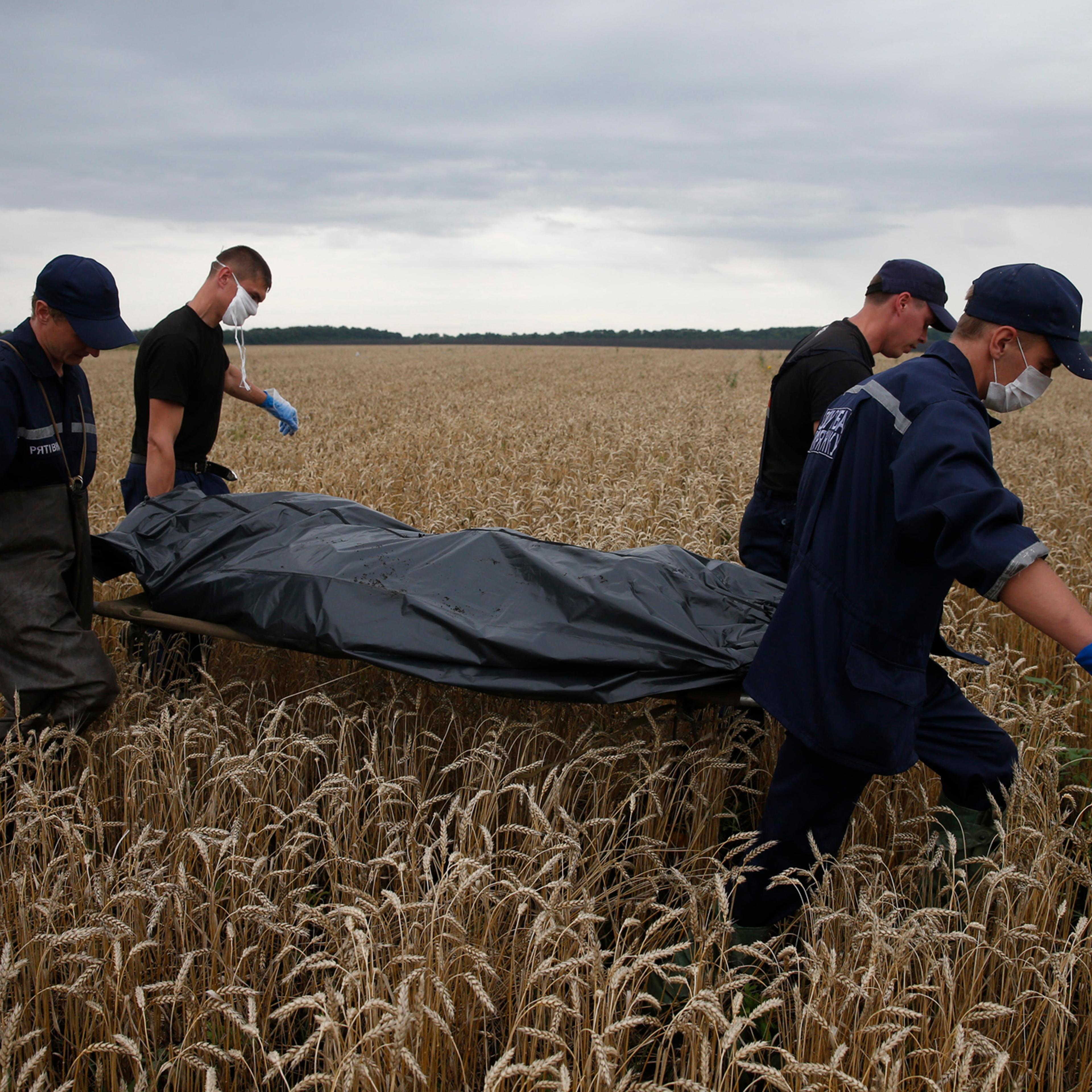 Emergency Workers carry a body at the crash site of Malaysia Airlines Flight MH17, near the settlement of Grabovo in the Donetsk region July 19, 2014.