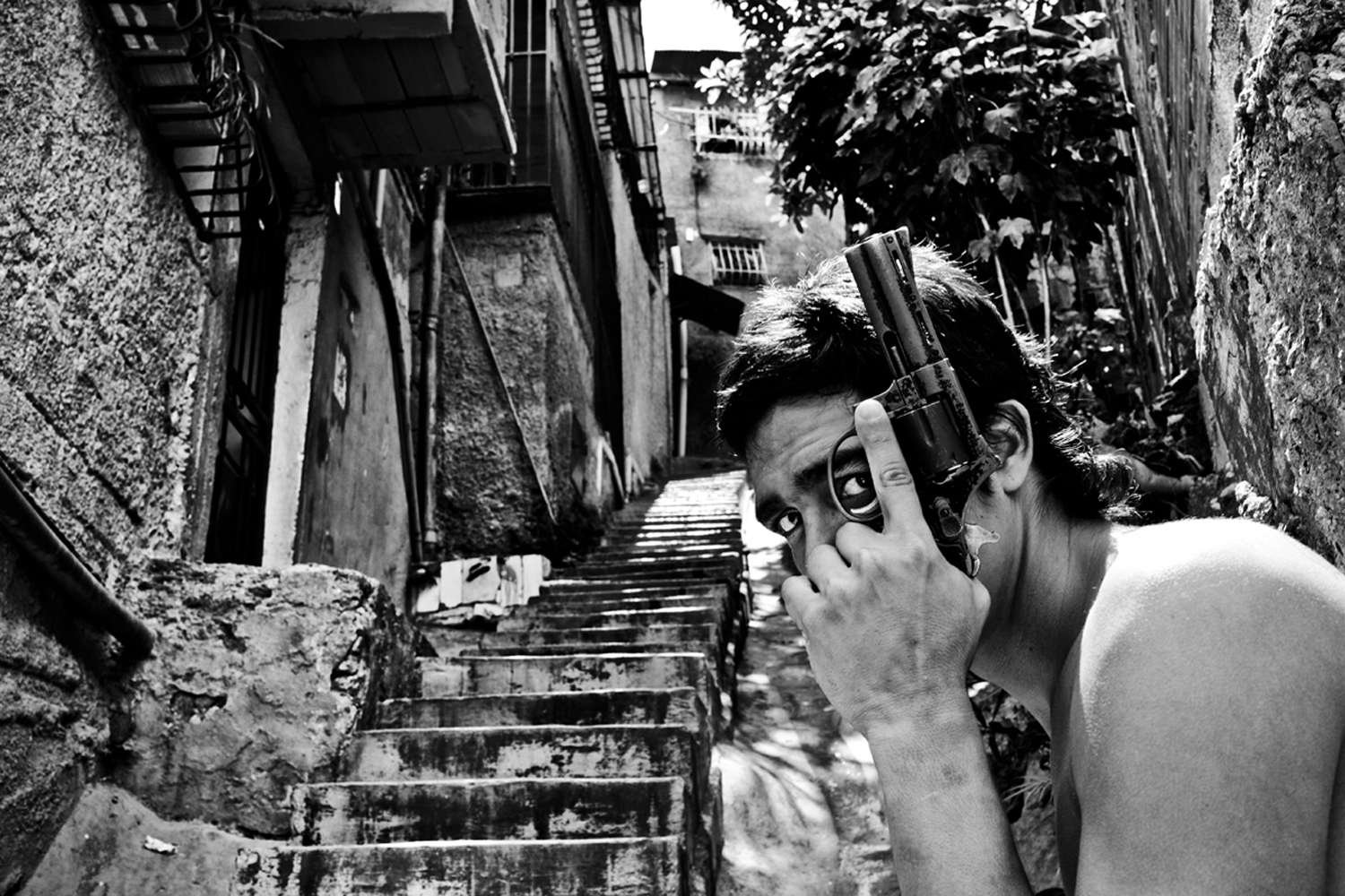 A gang member controls the alley where they sell drugs and posses with a revolver that is classic for this gang due to the years that have been in their hands. Between 50 and 100 murders take place in Caracas everyweek for a population of some 5 millions