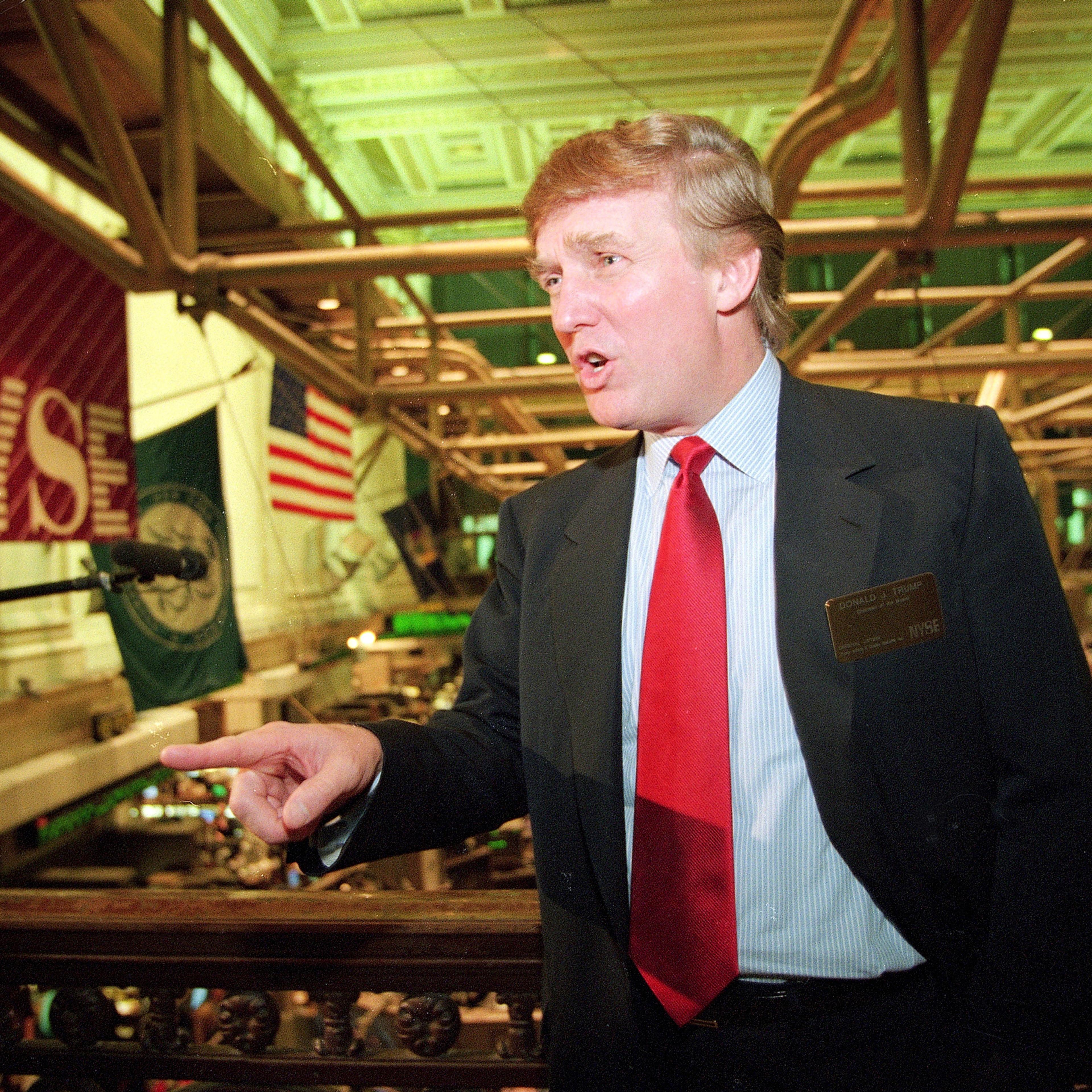 File-This June 7, 1995, file photo shows real estate magnate Donald Trump posing for photos above the floor of the New York Stock Exchange after taking his flagship Trump Plaza Casino public in New York City. Trump's business losses in 1995 were so large