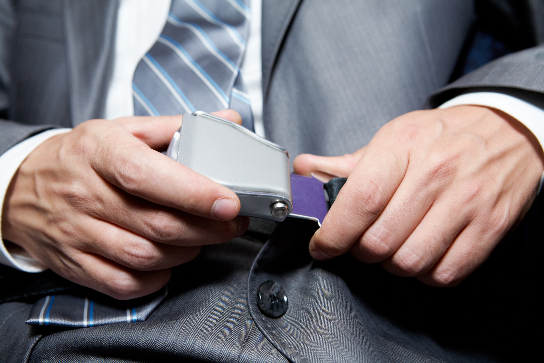 Businessman fastening his seatbelt for safety