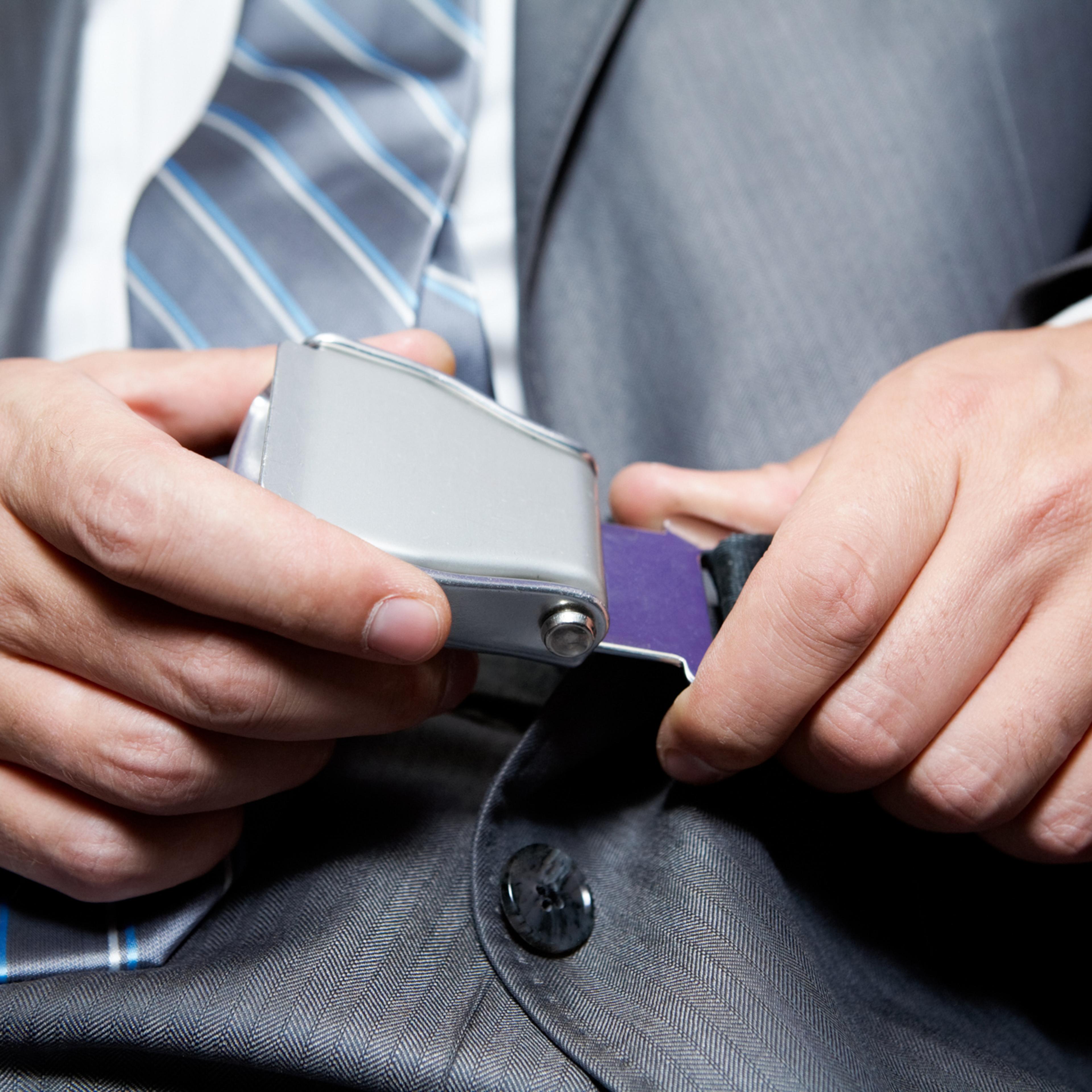 Businessman fastening his seatbelt for safety