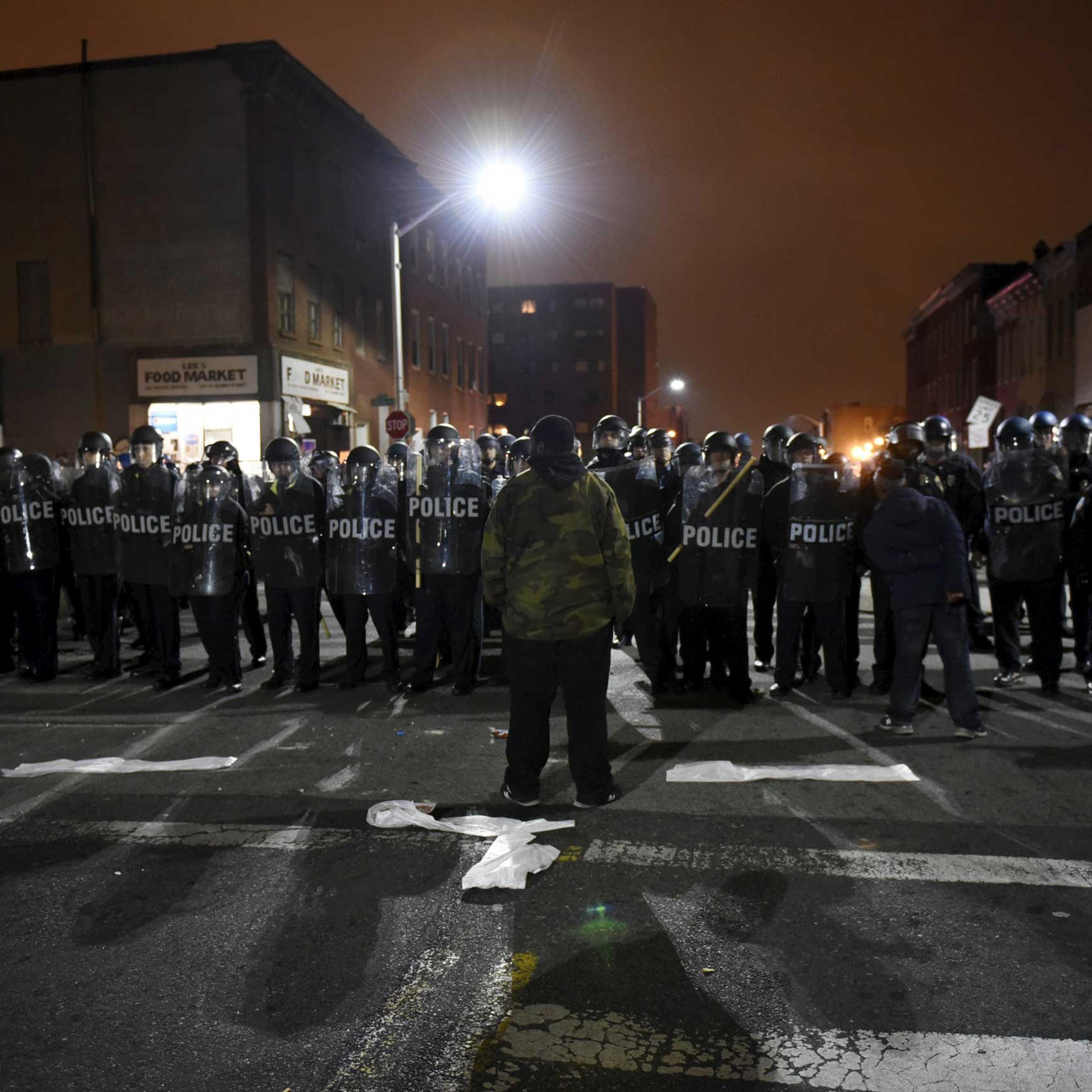 A demonstrator confronts law enforcement officers near Baltimore Police Department Western District in Baltimore on April 25, 2015.