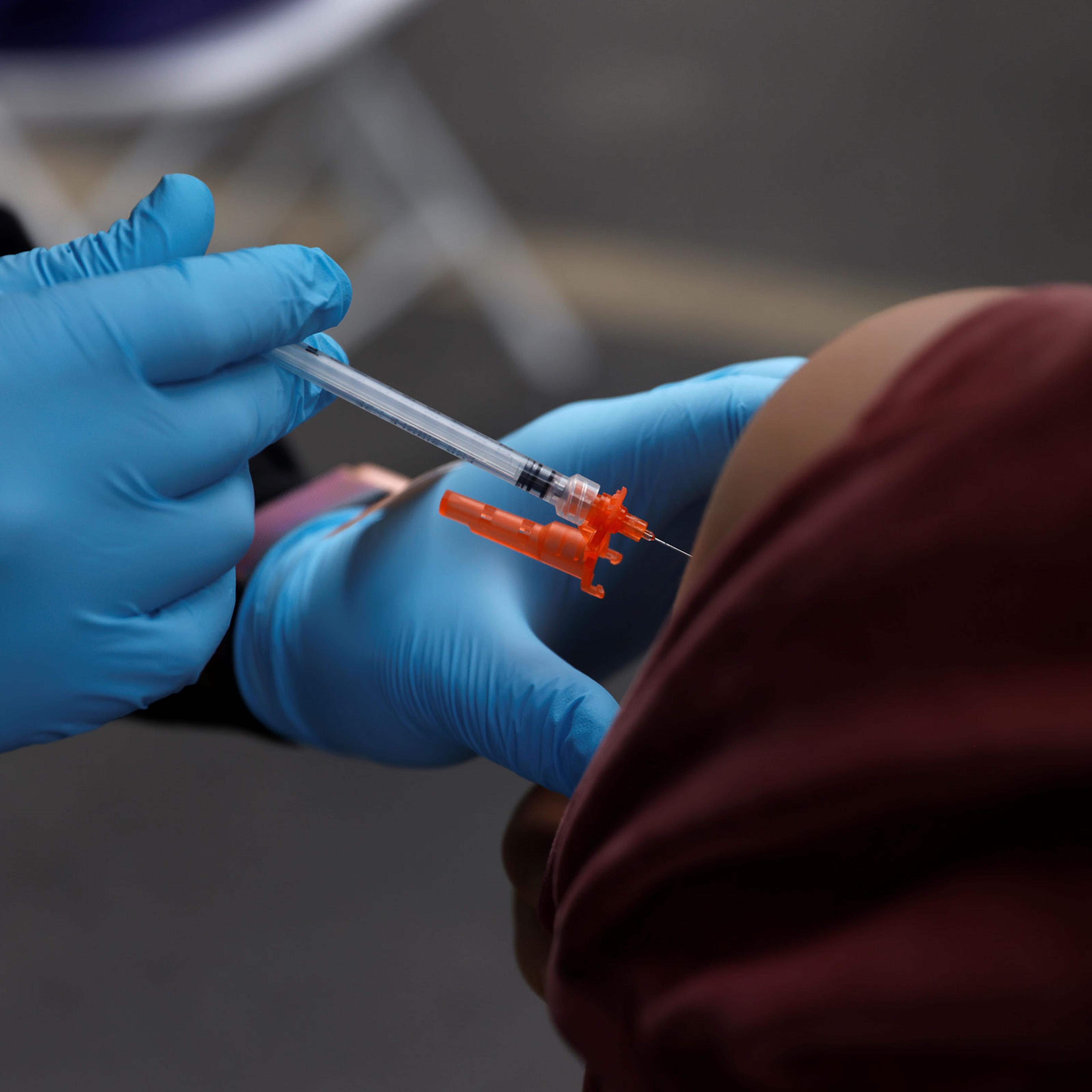A health care administer gives the second dose of the Pfizer-BioNTech COVID-19 vaccine