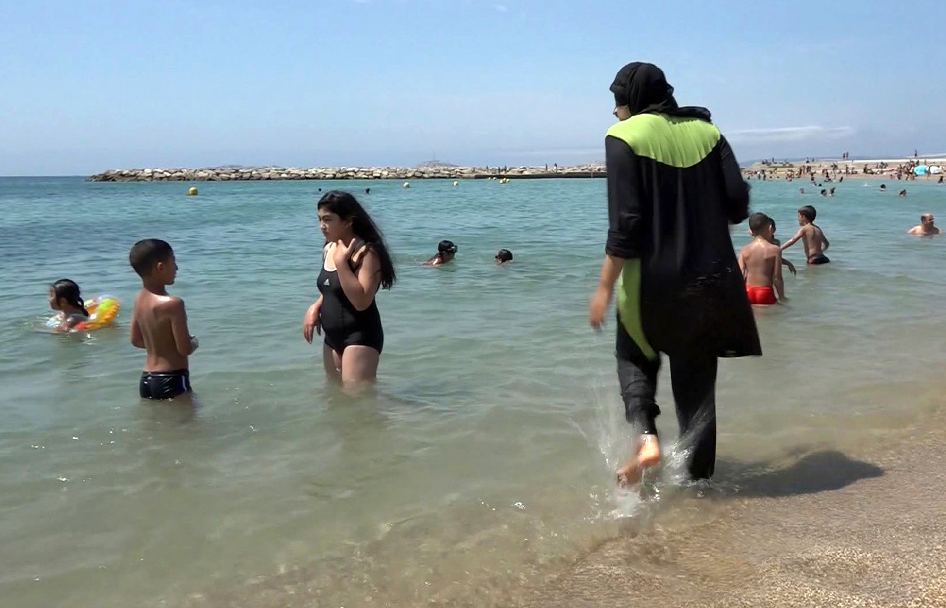 Nissrine Samali, 20, gets into the sea wearing a burkini, a wetsuit-like garment that also covers the head, in Marseille, southern France, Aug. 4, 2016. France's Socialist prime minister Manuel Valls is expressing support for local bans of burkinis, sayi