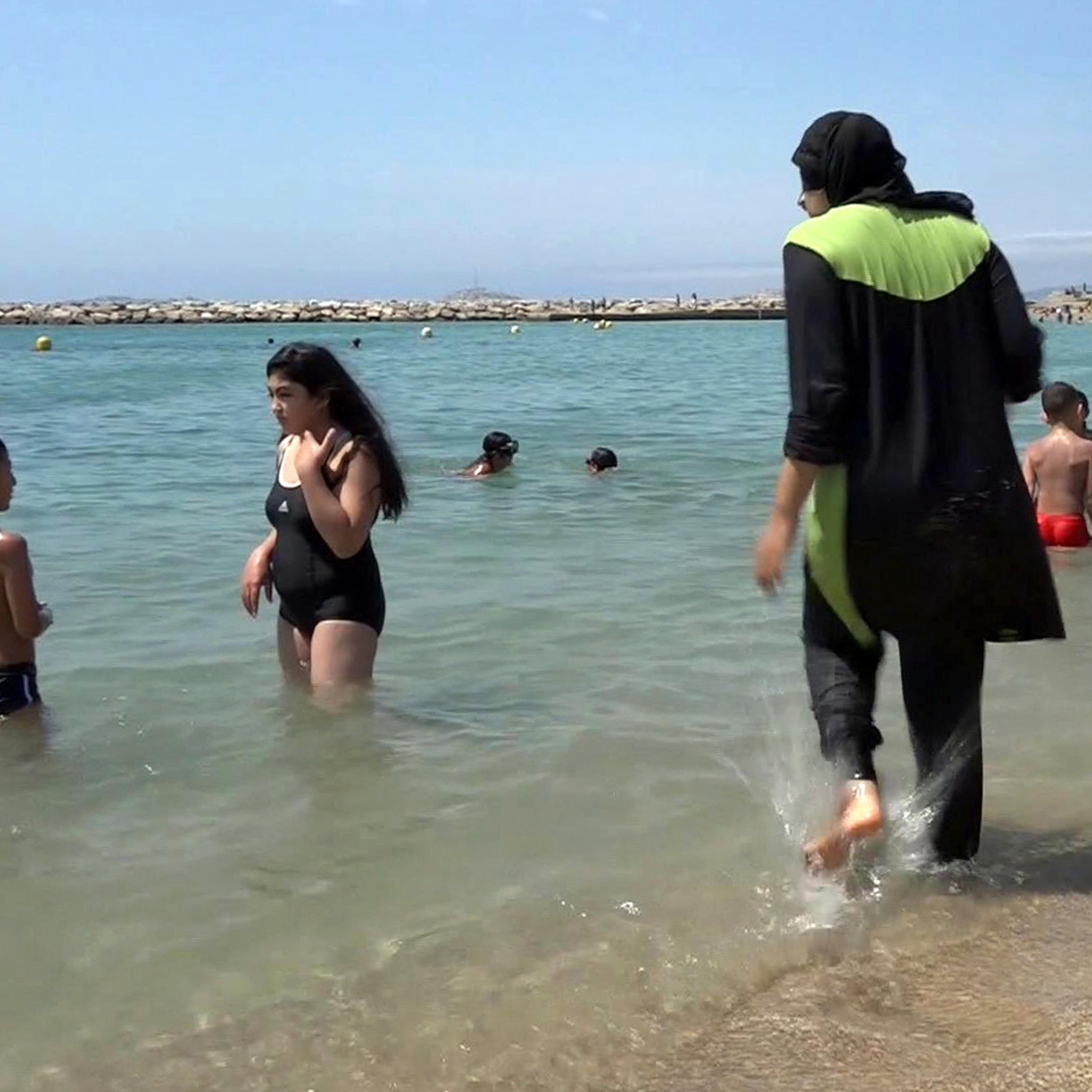 Nissrine Samali, 20, gets into the sea wearing a burkini, a wetsuit-like garment that also covers the head, in Marseille, southern France, Aug. 4, 2016. France's Socialist prime minister Manuel Valls is expressing support for local bans of burkinis, sayi