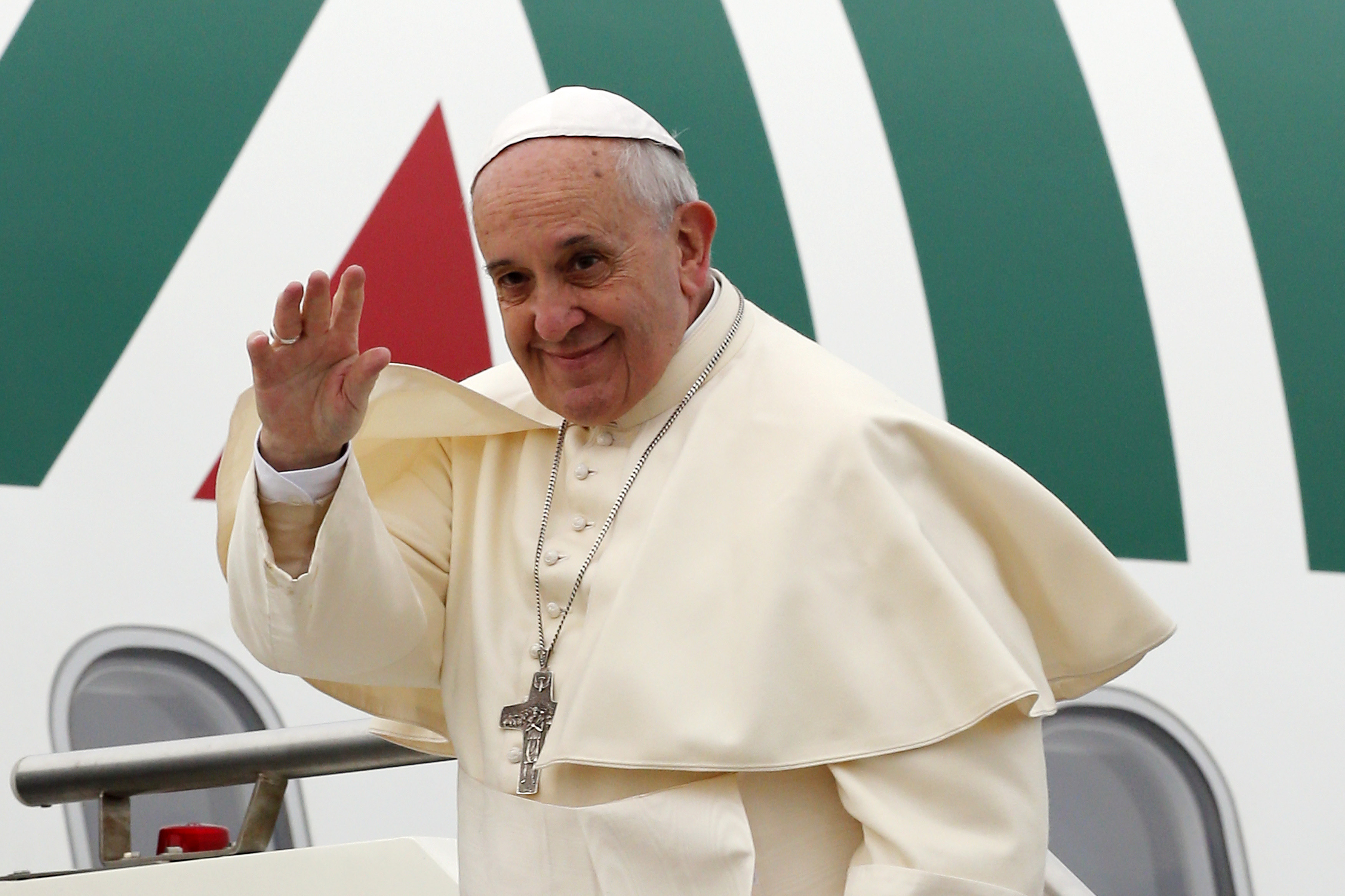 Pope Francis waves as he boards a plane at Fiumicino Airport in Rome
