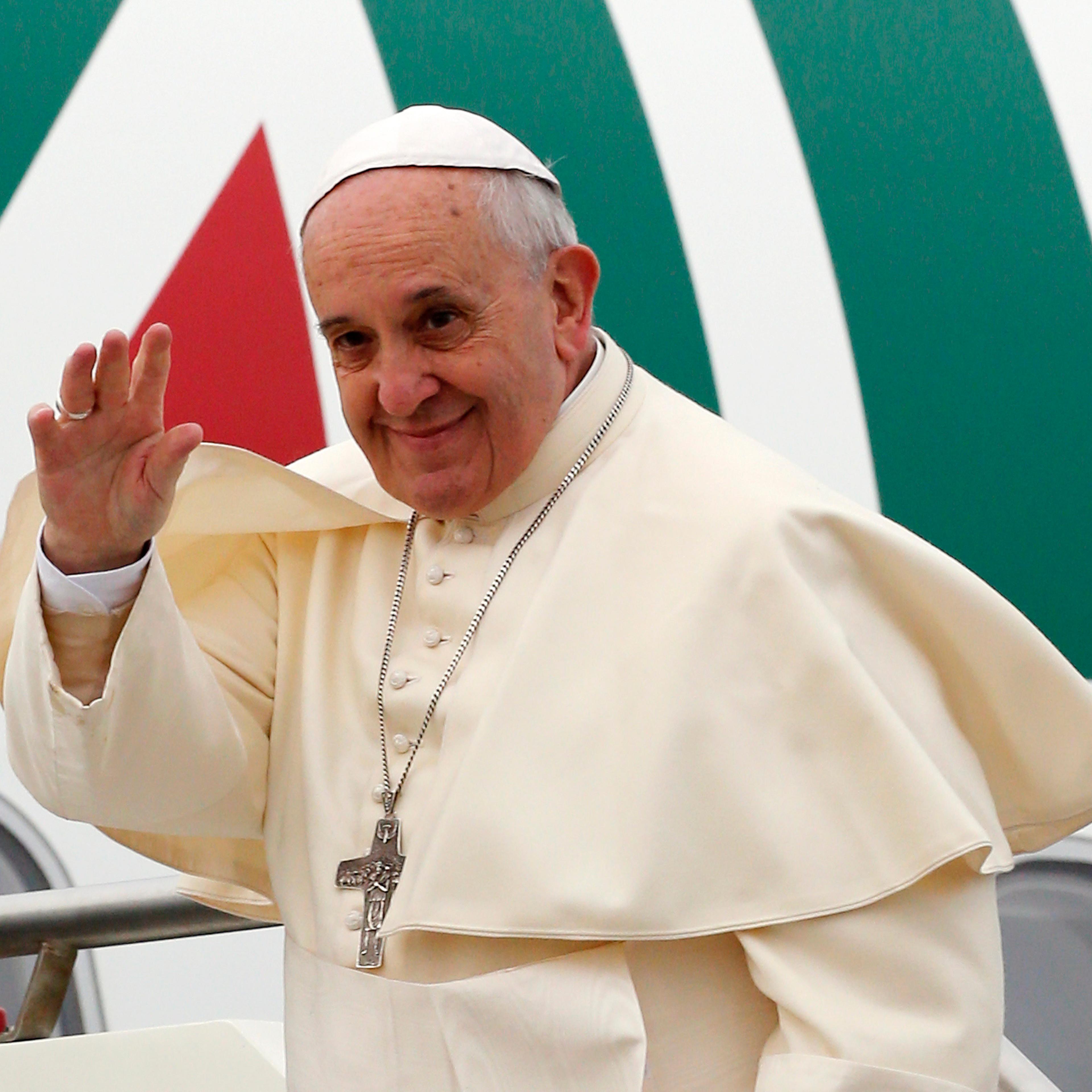 Pope Francis waves as he boards a plane at Fiumicino Airport in Rome