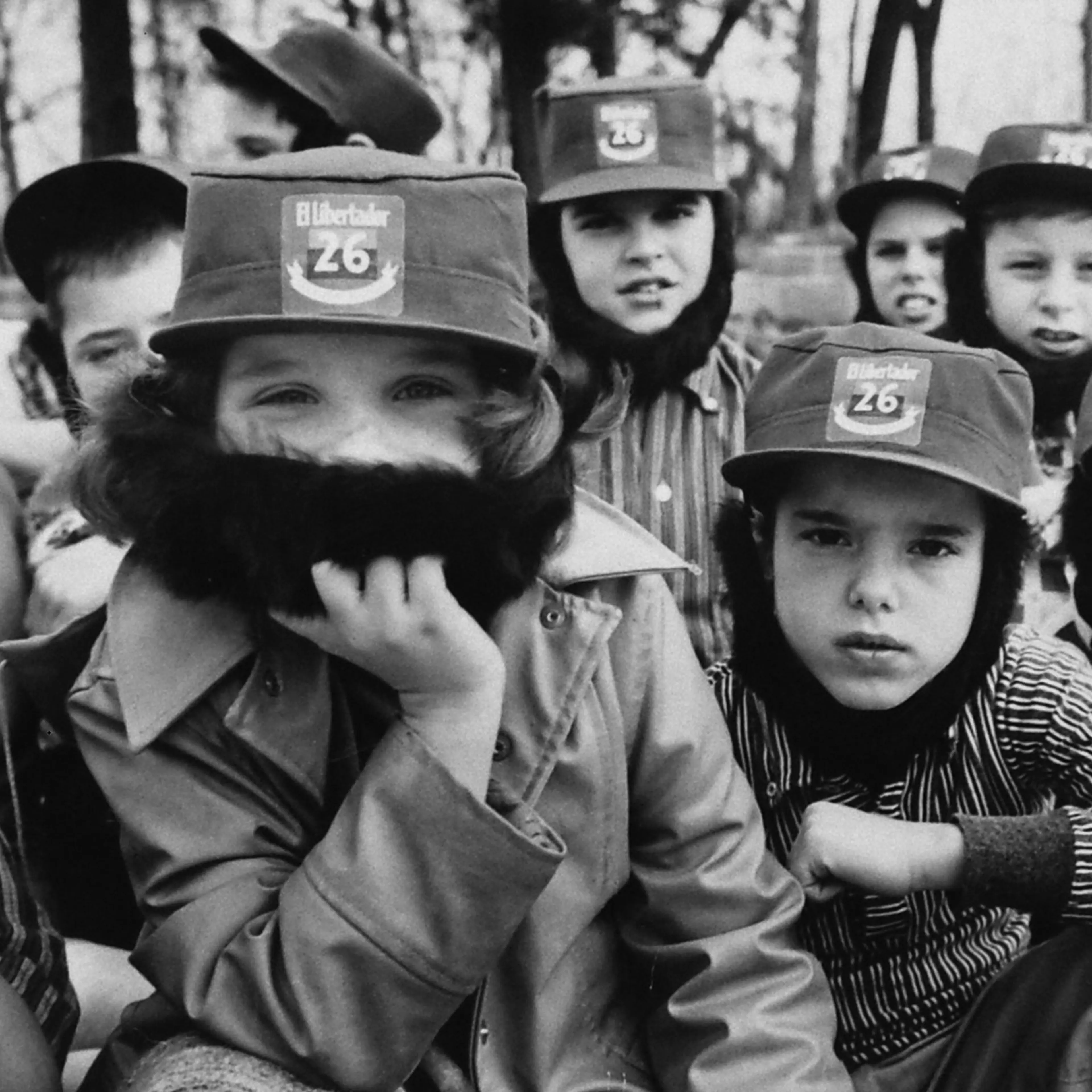 Children wearing Fidel Castro beards and hats, playing in the woods in 1959.