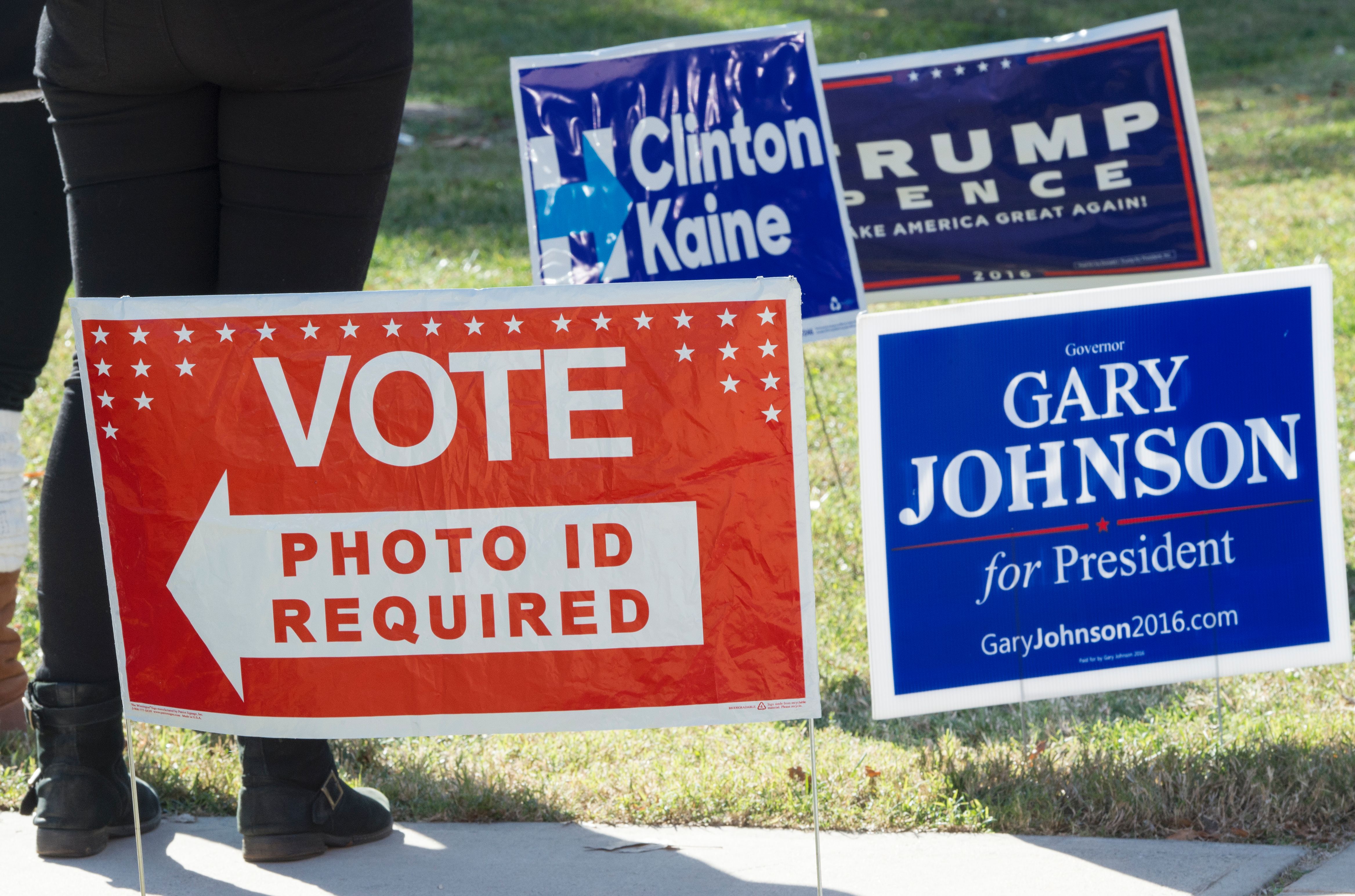 Signs are seen on a lawn near a US polling place in Arlington, Virginia, November 8, 2016.