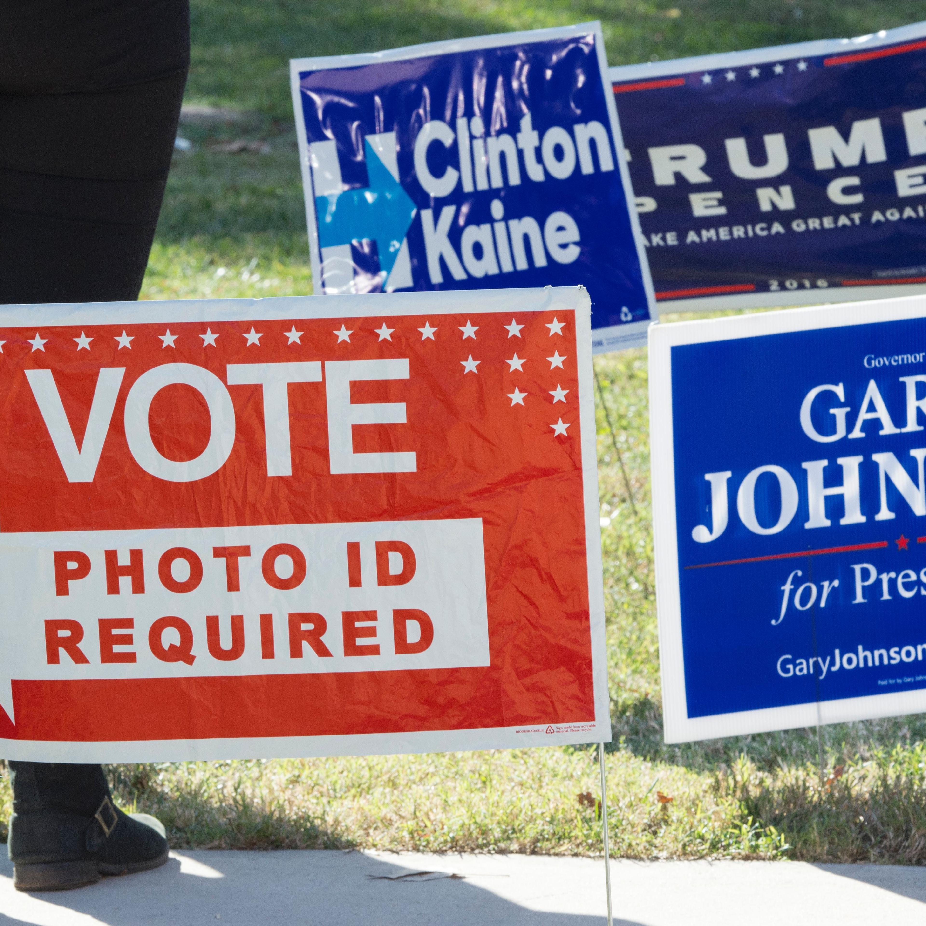 Signs are seen on a lawn near a US polling place in Arlington, Virginia, November 8, 2016.
