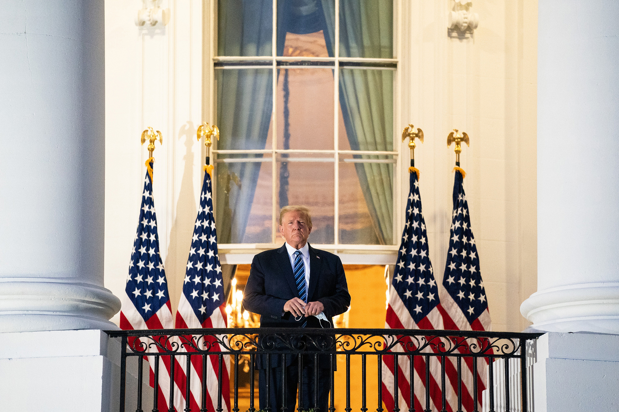President Donald Trump stands on the Truman Balcony upon returning to the White House on Oct. 5 after testing positive for COVID-19 and spending four days at the the Walter Reed Medical Center in Bethesda, Md