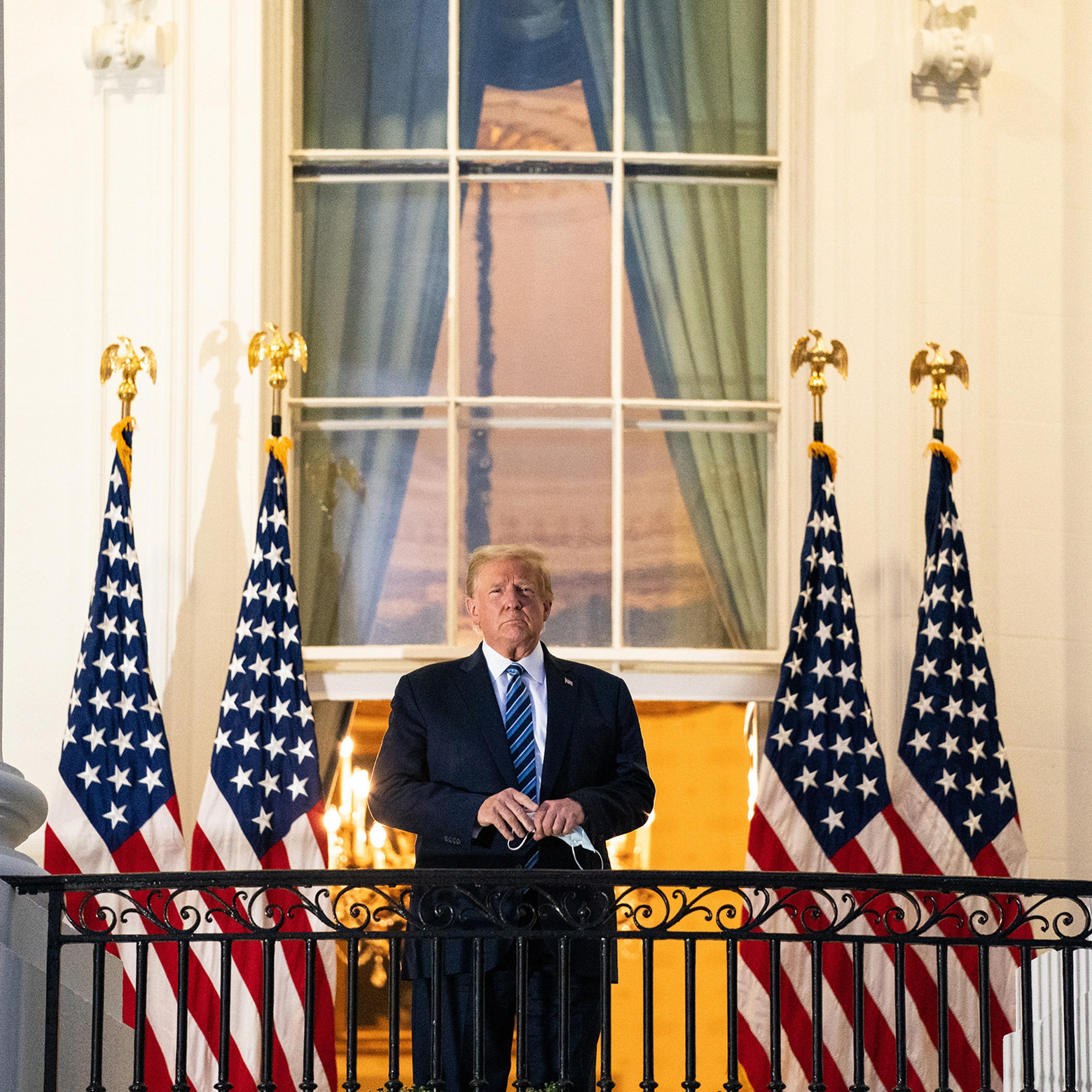 President Donald Trump stands on the Truman Balcony upon returning to the White House on Oct. 5 after testing positive for COVID-19 and spending four days at the the Walter Reed Medical Center in Bethesda, Md