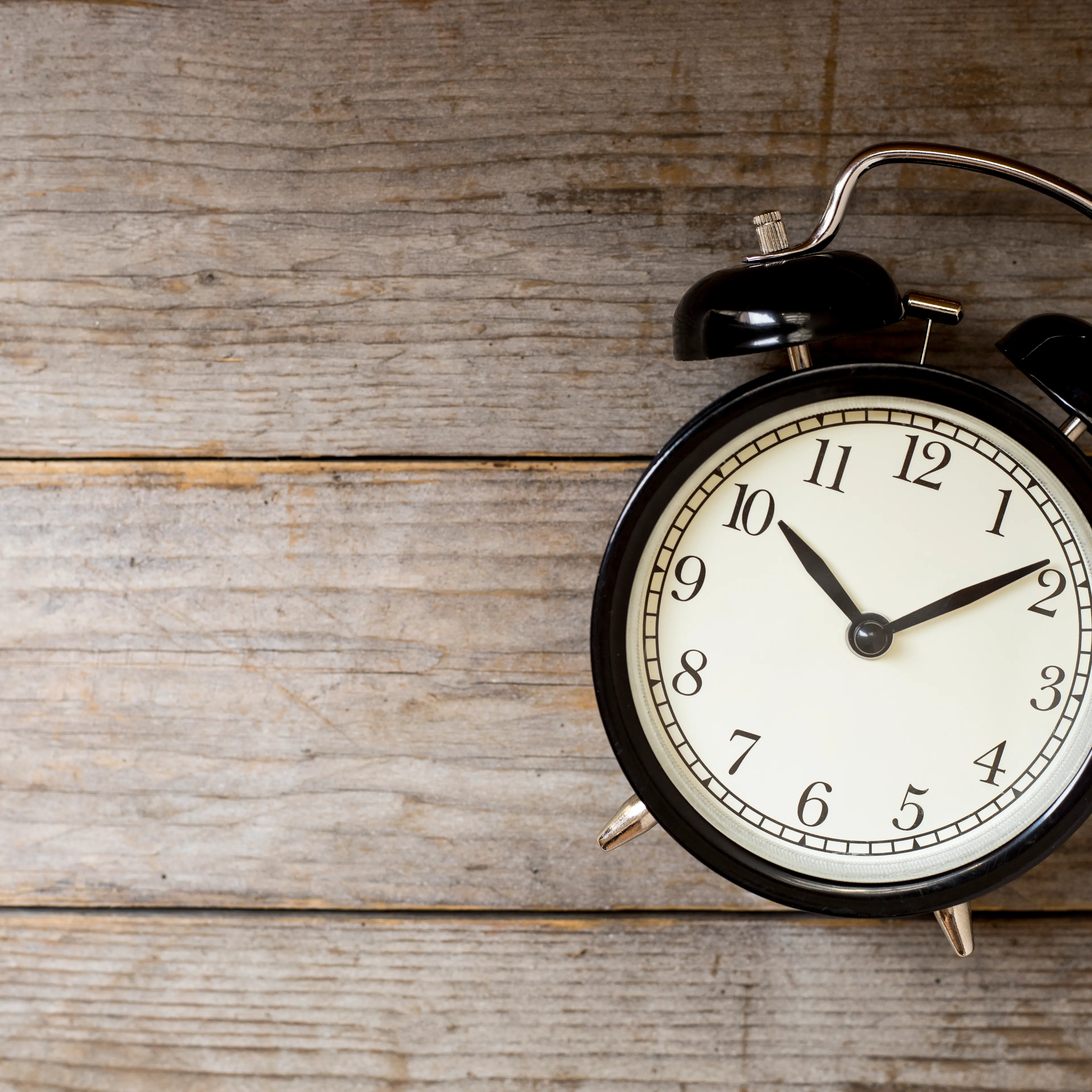 Retro alarm clock on wooden table