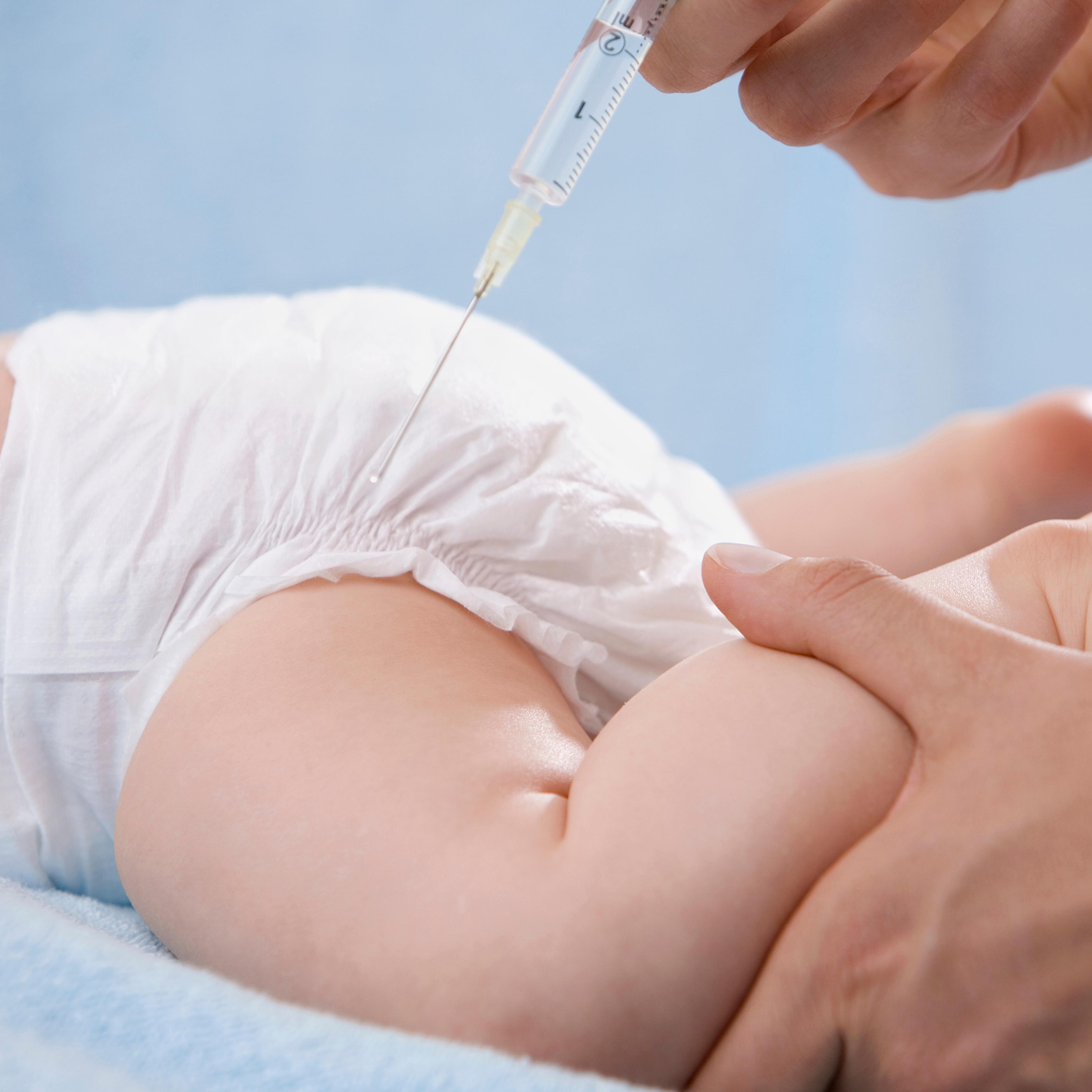 Female doctor injecting baby, close-up