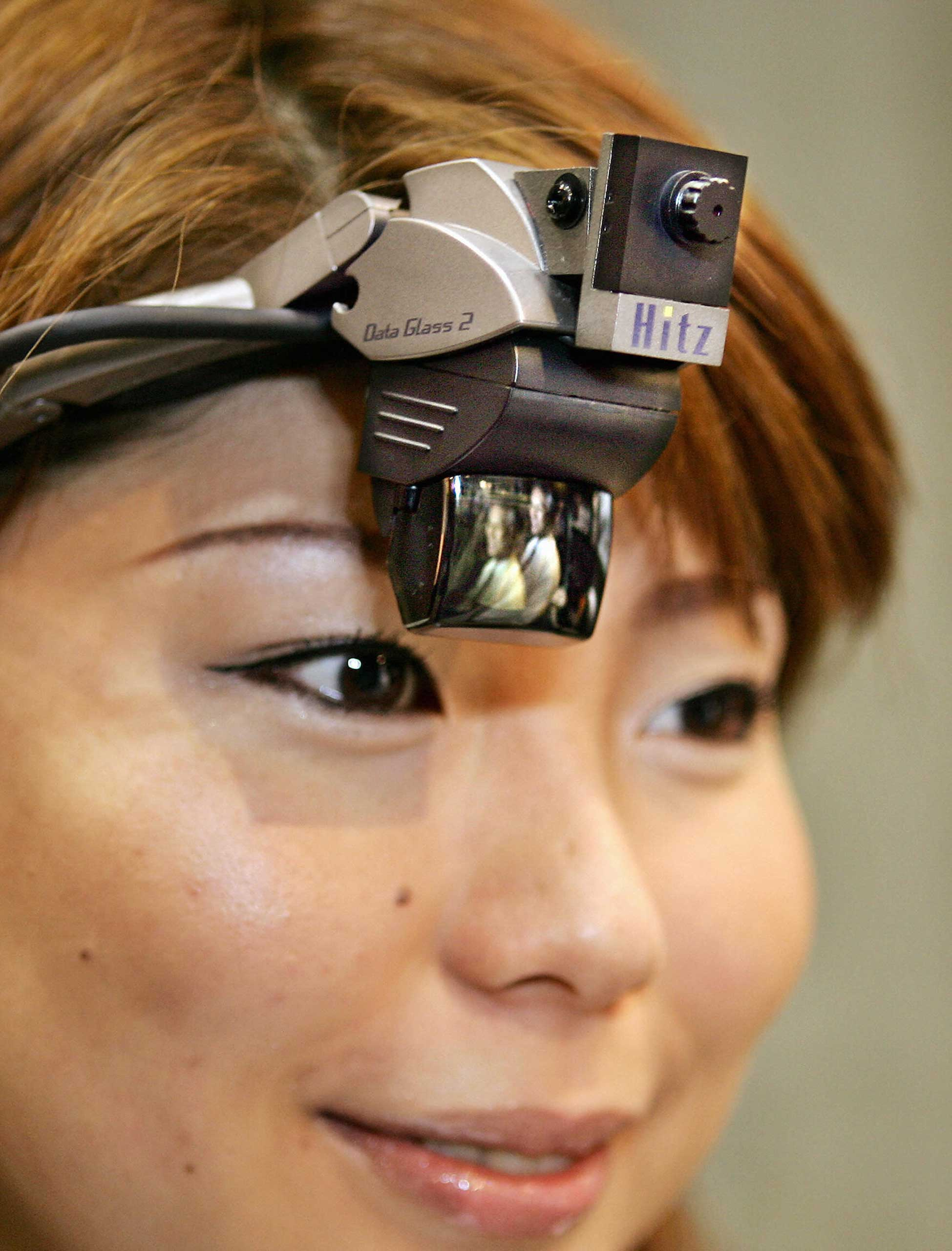 A girl wore a full color head mounted display with a built-in camera as Japan's machinery maker Hitachi Zosen and Shimadzu unveiled a wearable computer, consisting of the HMD and a palm sized Windows XP PC with a pointing device at a virtual reality exhi