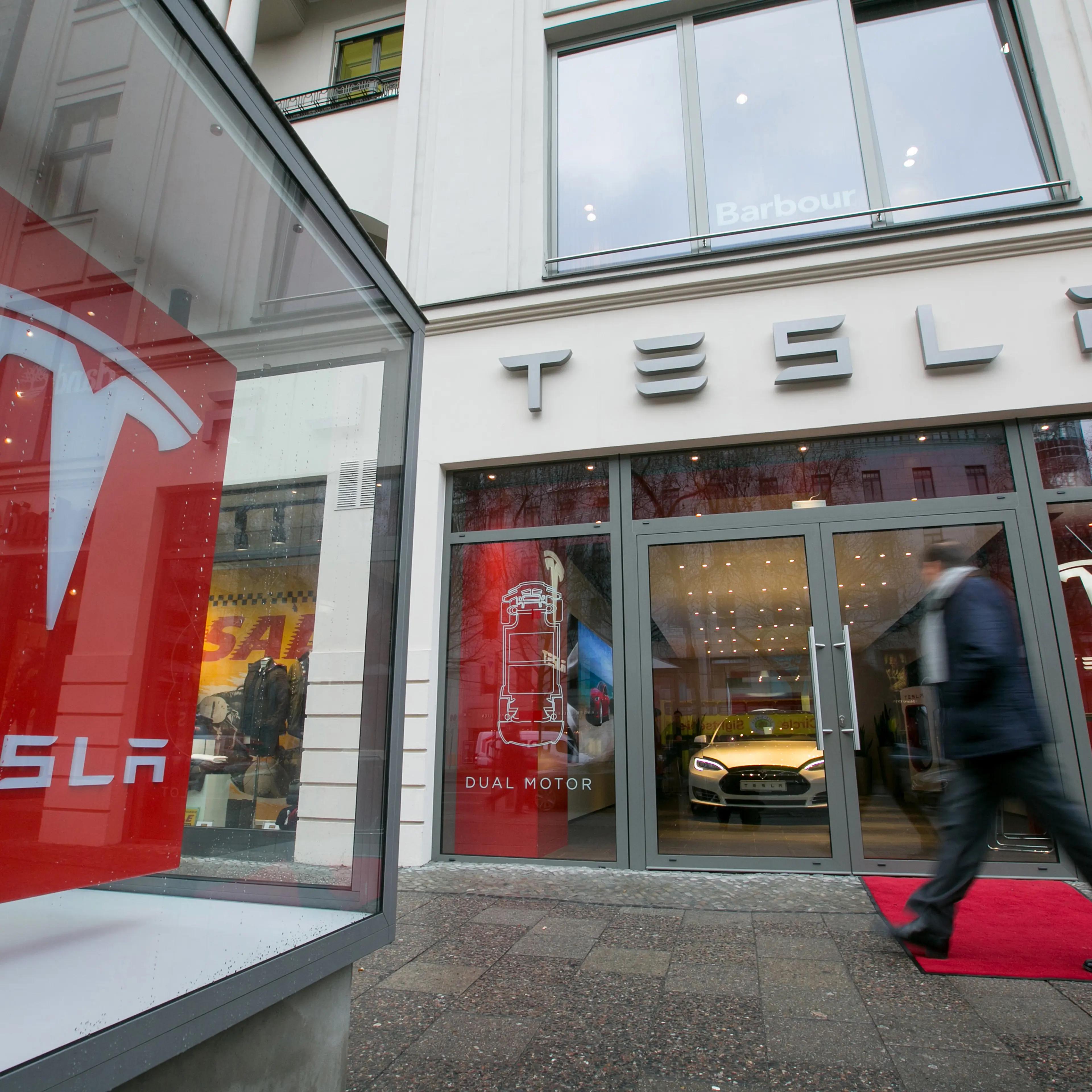 A pedestrian passes a Tesla Motors Inc. electric automobile showroom in Berlin, Germany, on Wednesday, Jan. 7, 2015.