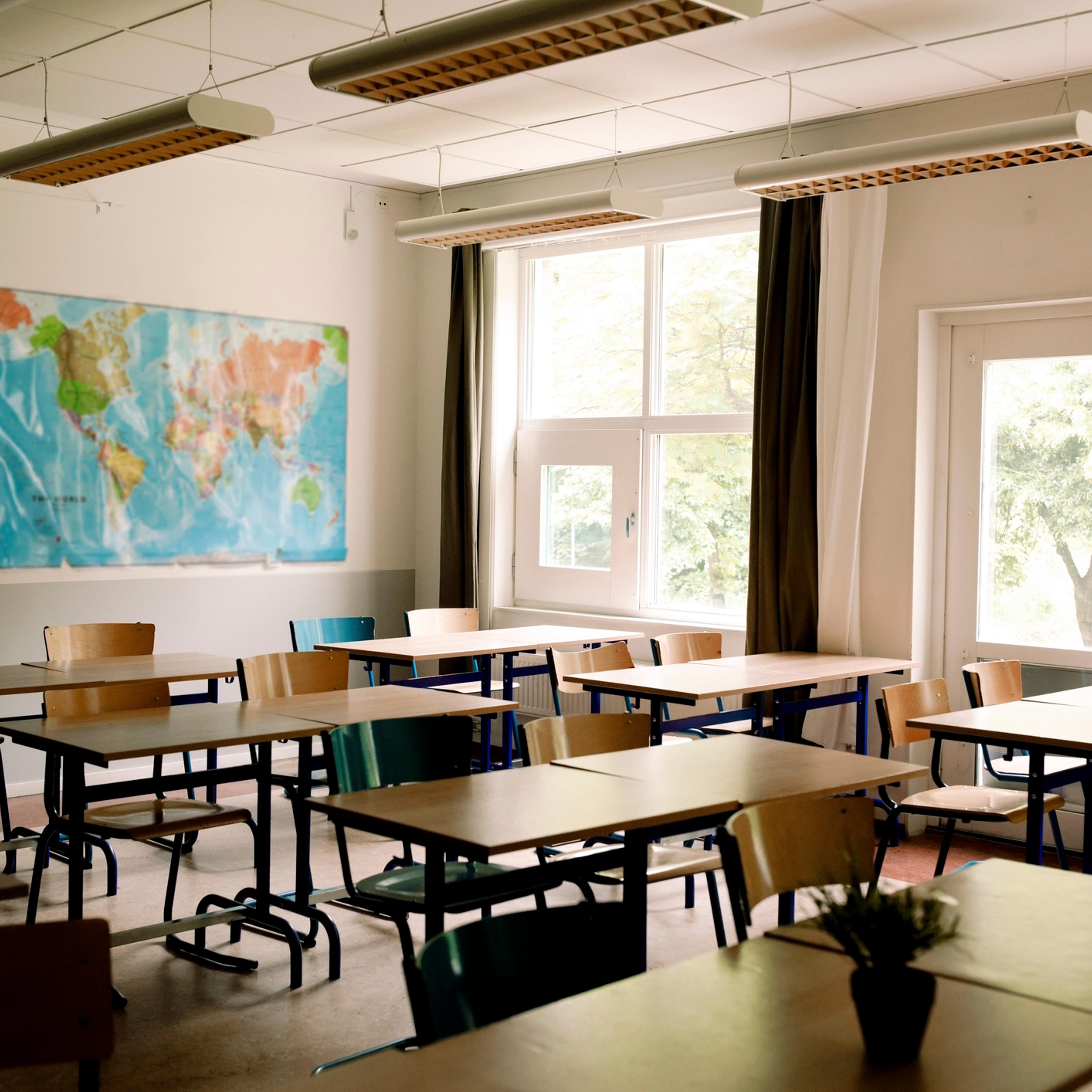 Empty desks and chairs arranged in classroom at high school