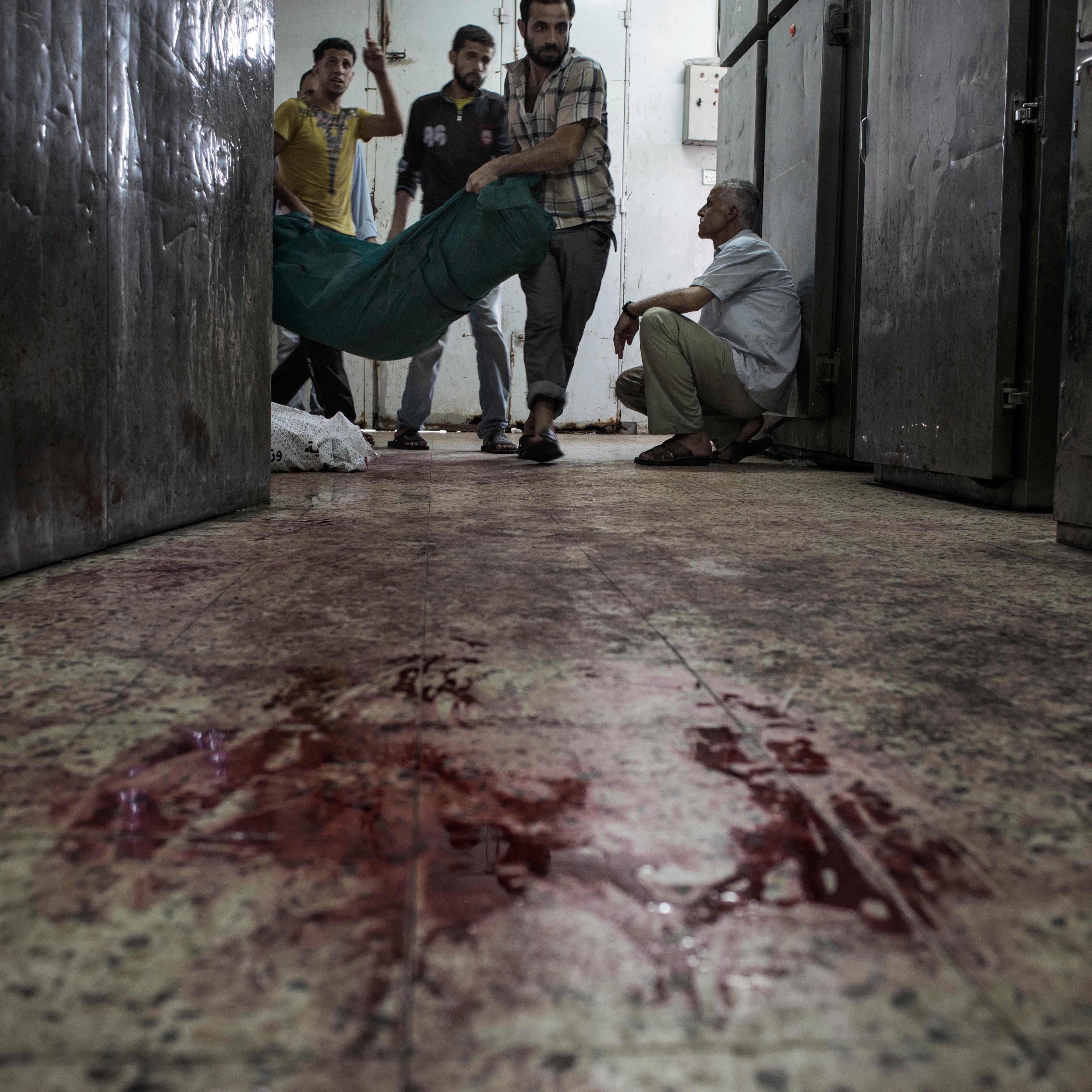 Palestinians carry a body into the Shifa Hospital morgue, Gaza City, July 20, 2014.