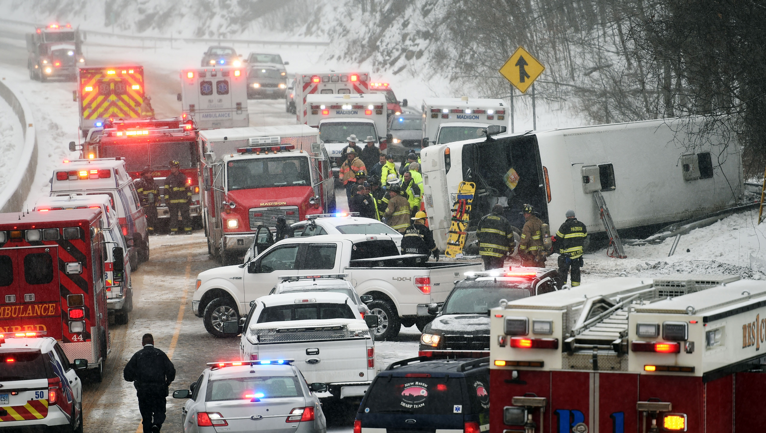 Emergency responders work at the scene of a tour bus rollover on Interstate 95 northbound in the area of exit 61 on Monday, February 8, 2016 in Madison, Conn. At least 30 people were injured, several critically, in the accident. The bus was traveling fro