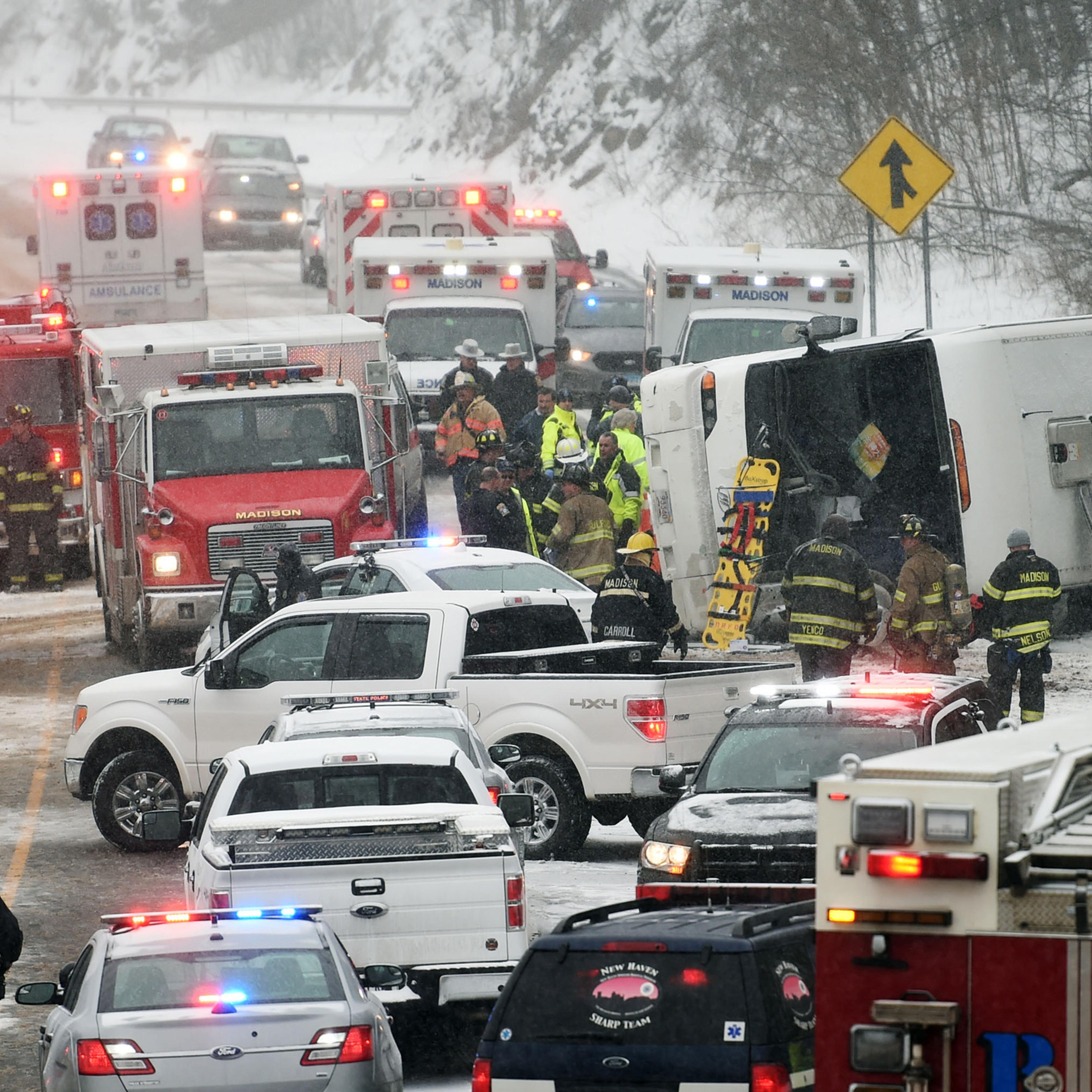 Emergency responders work at the scene of a tour bus rollover on Interstate 95 northbound in the area of exit 61 on Monday, February 8, 2016 in Madison, Conn. At least 30 people were injured, several critically, in the accident. The bus was traveling fro